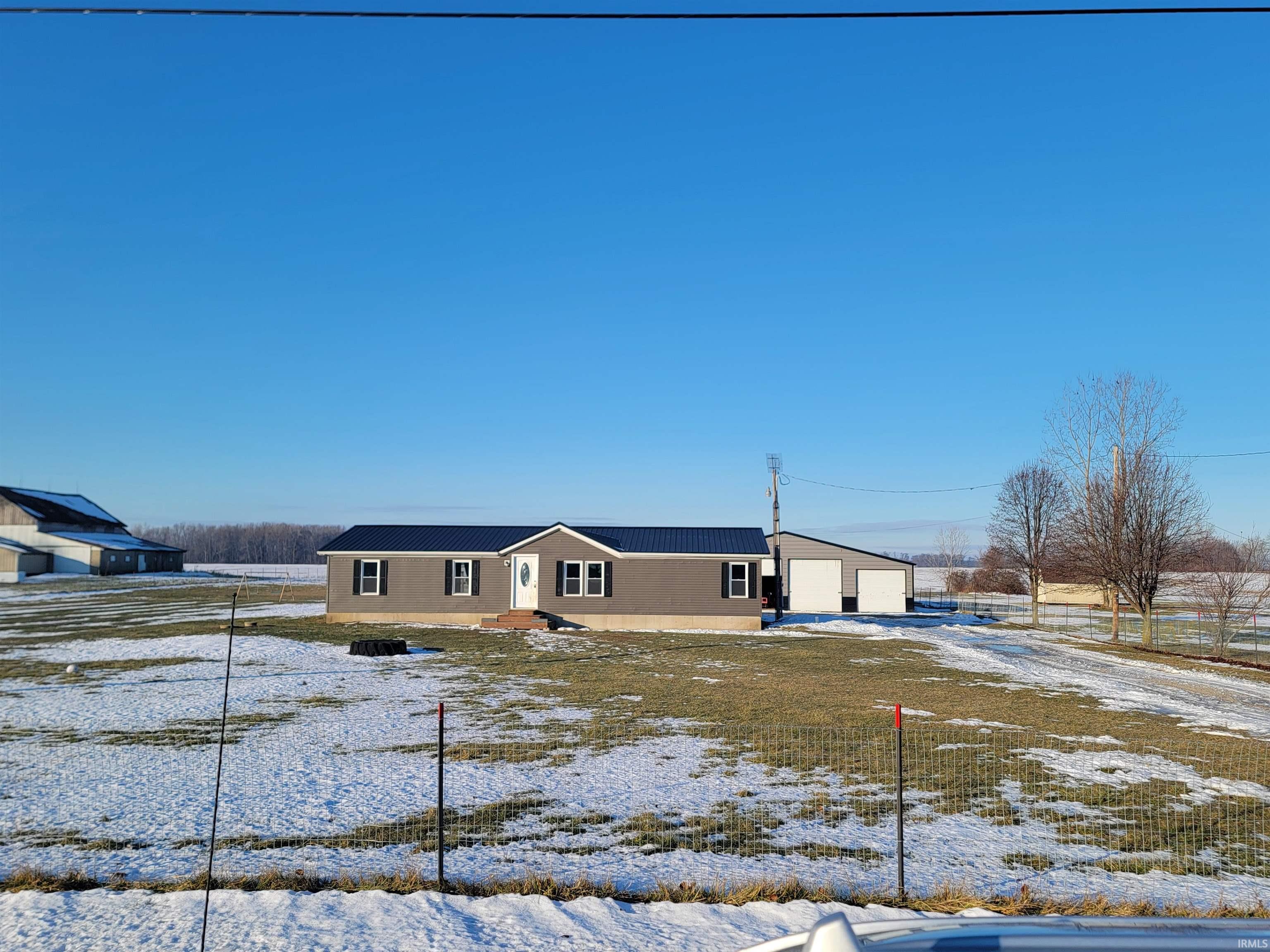 View of front of home with a detached garage and a metal roof