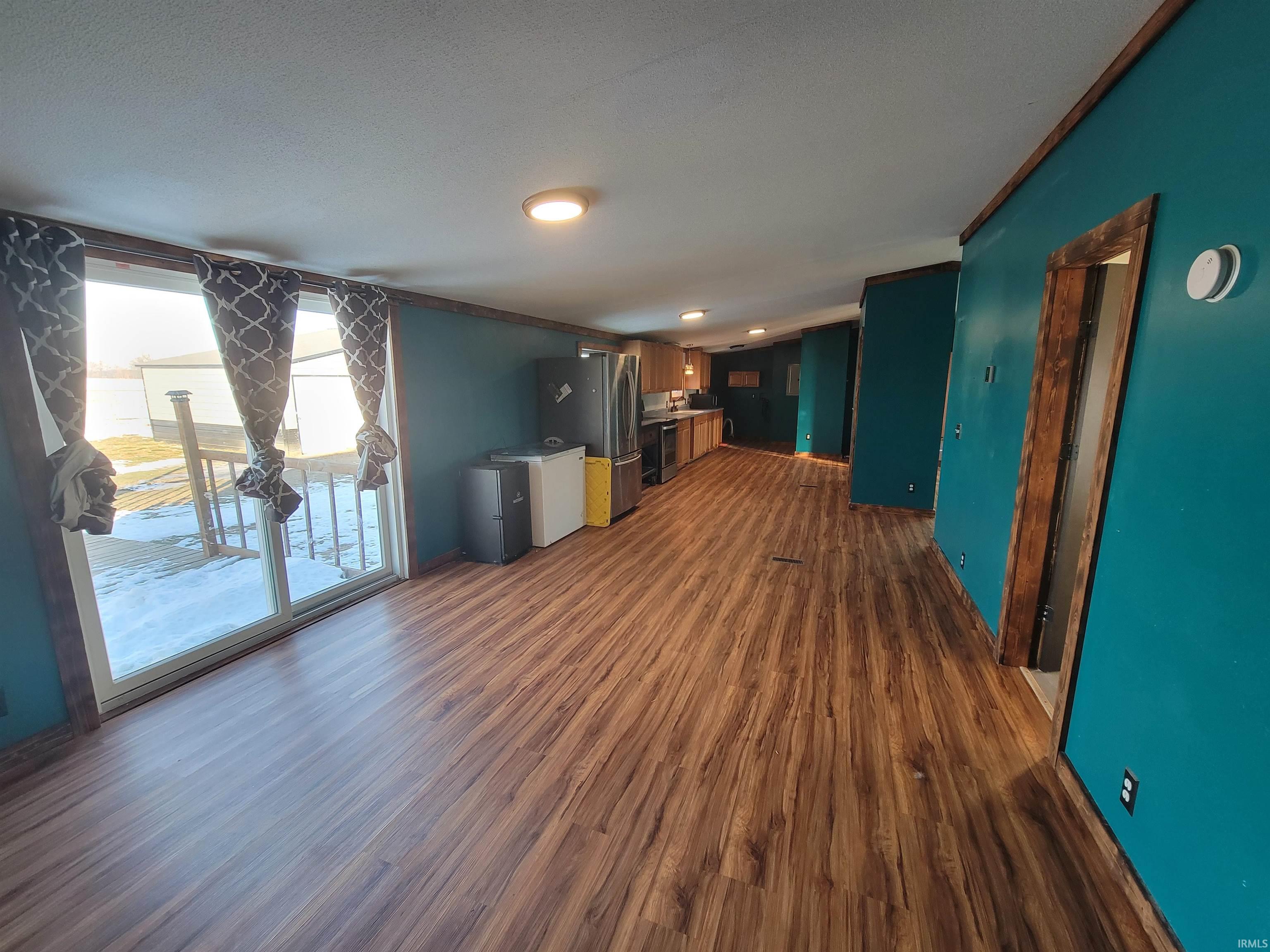 Unfurnished living room with dark wood-style floors and a textured ceiling