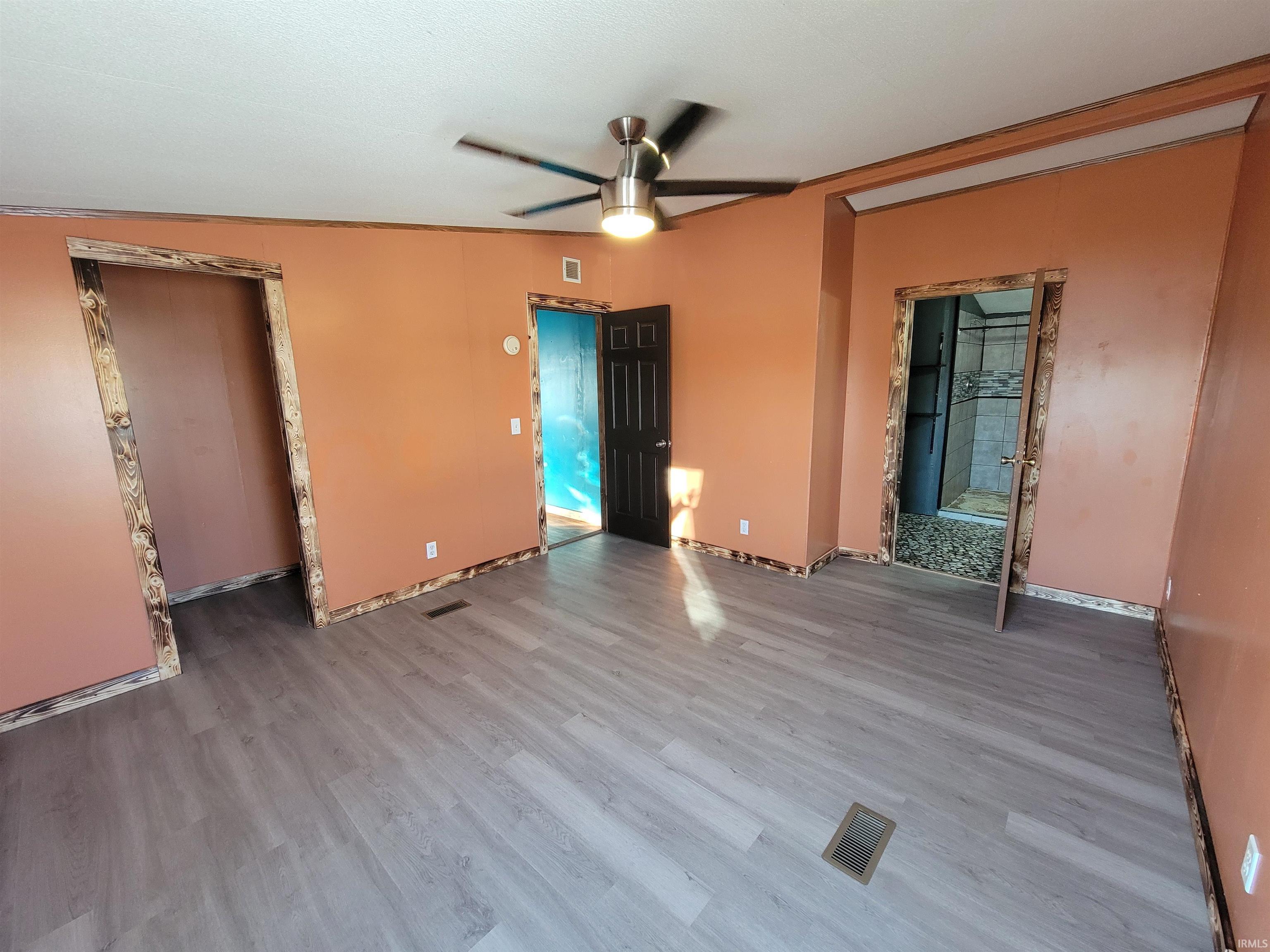 Empty room with a ceiling fan and wood finished floors