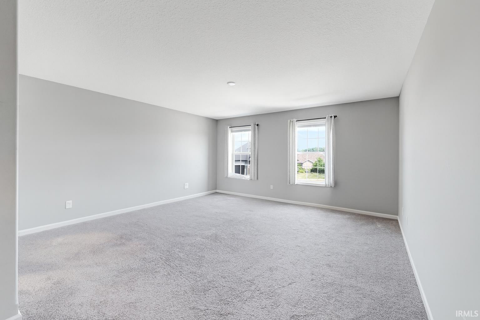 Carpeted spare room with baseboards and a textured ceiling