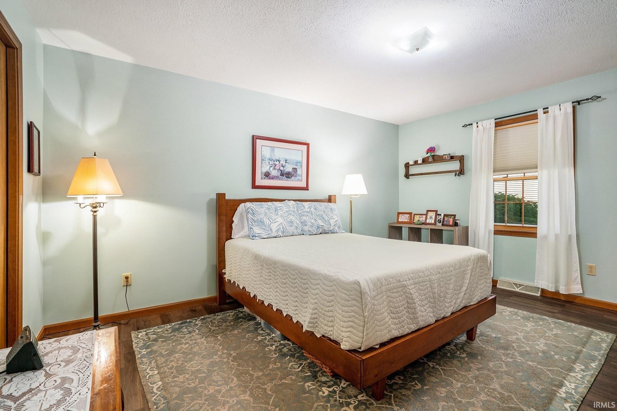 Bedroom featuring wood finished floors and a textured ceiling