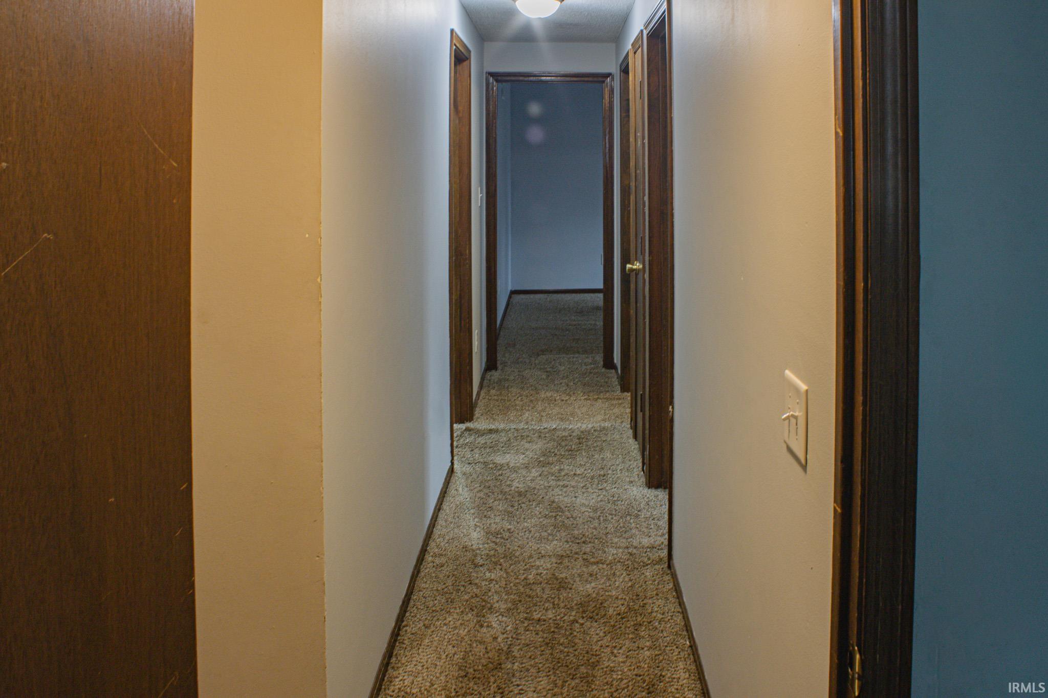 Corridor featuring light carpet