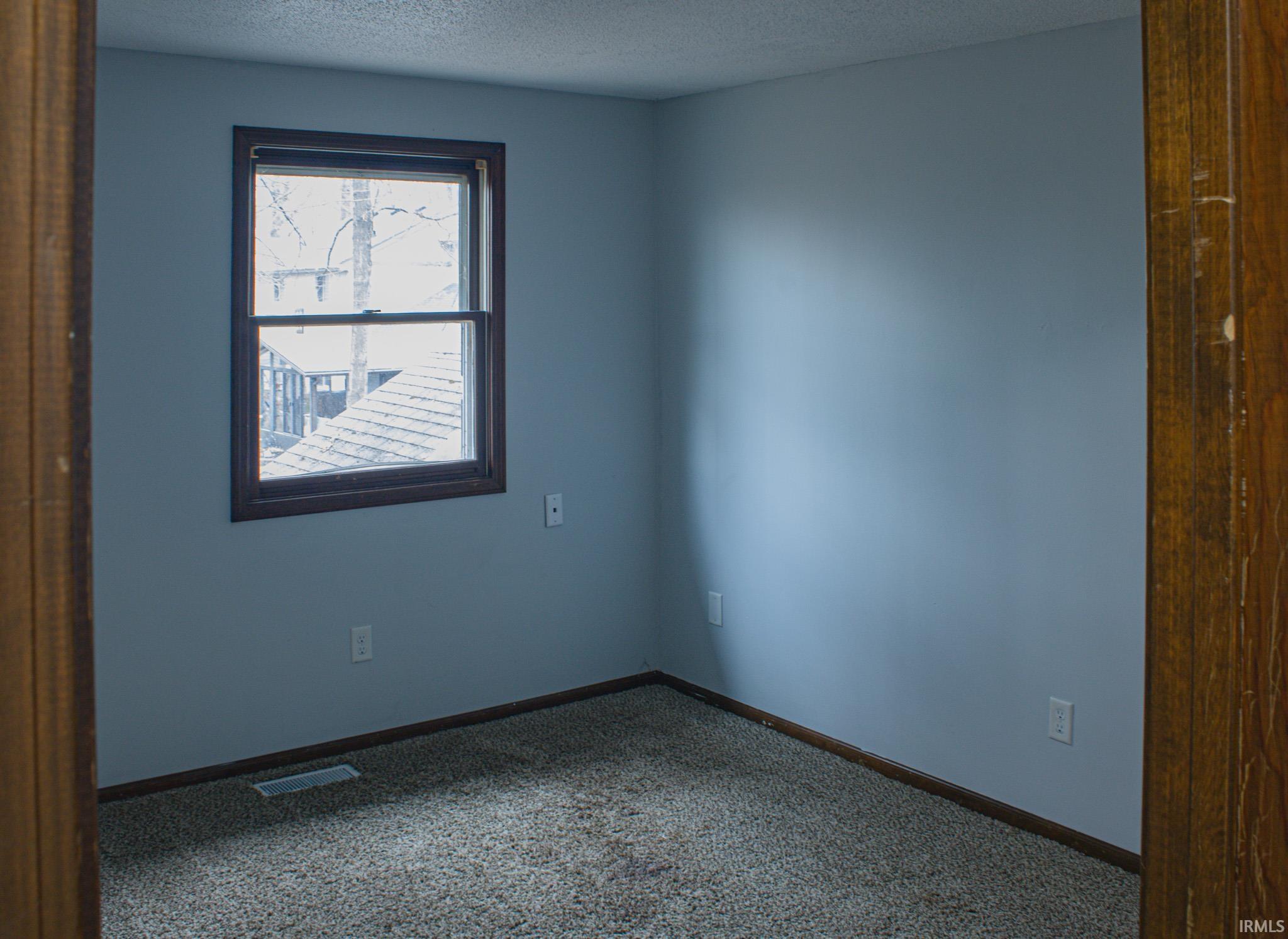 Spare room with carpet and a textured ceiling