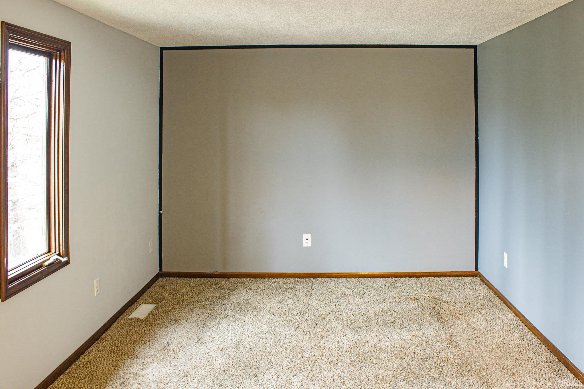 Unfurnished room featuring carpet flooring and a textured ceiling