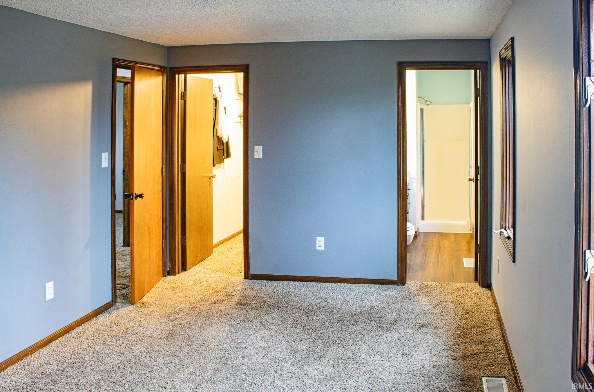 Unfurnished bedroom with carpet and a textured ceiling