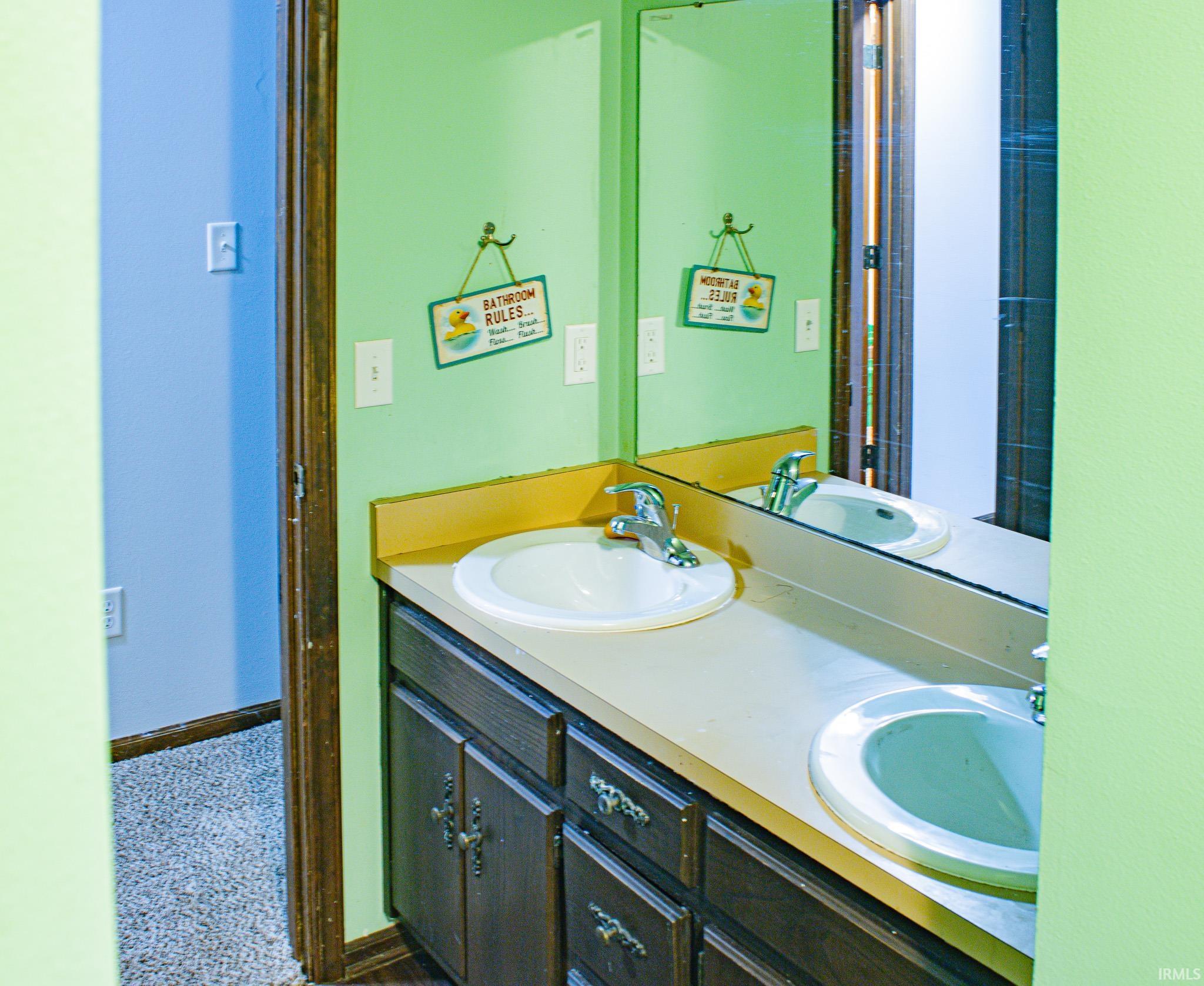 Bathroom with double vanity and baseboards