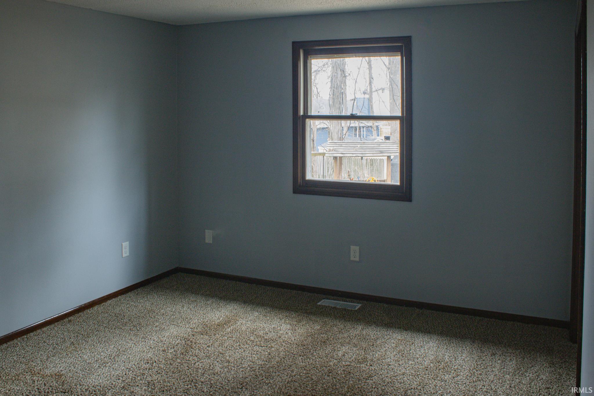 Carpeted spare room with baseboards