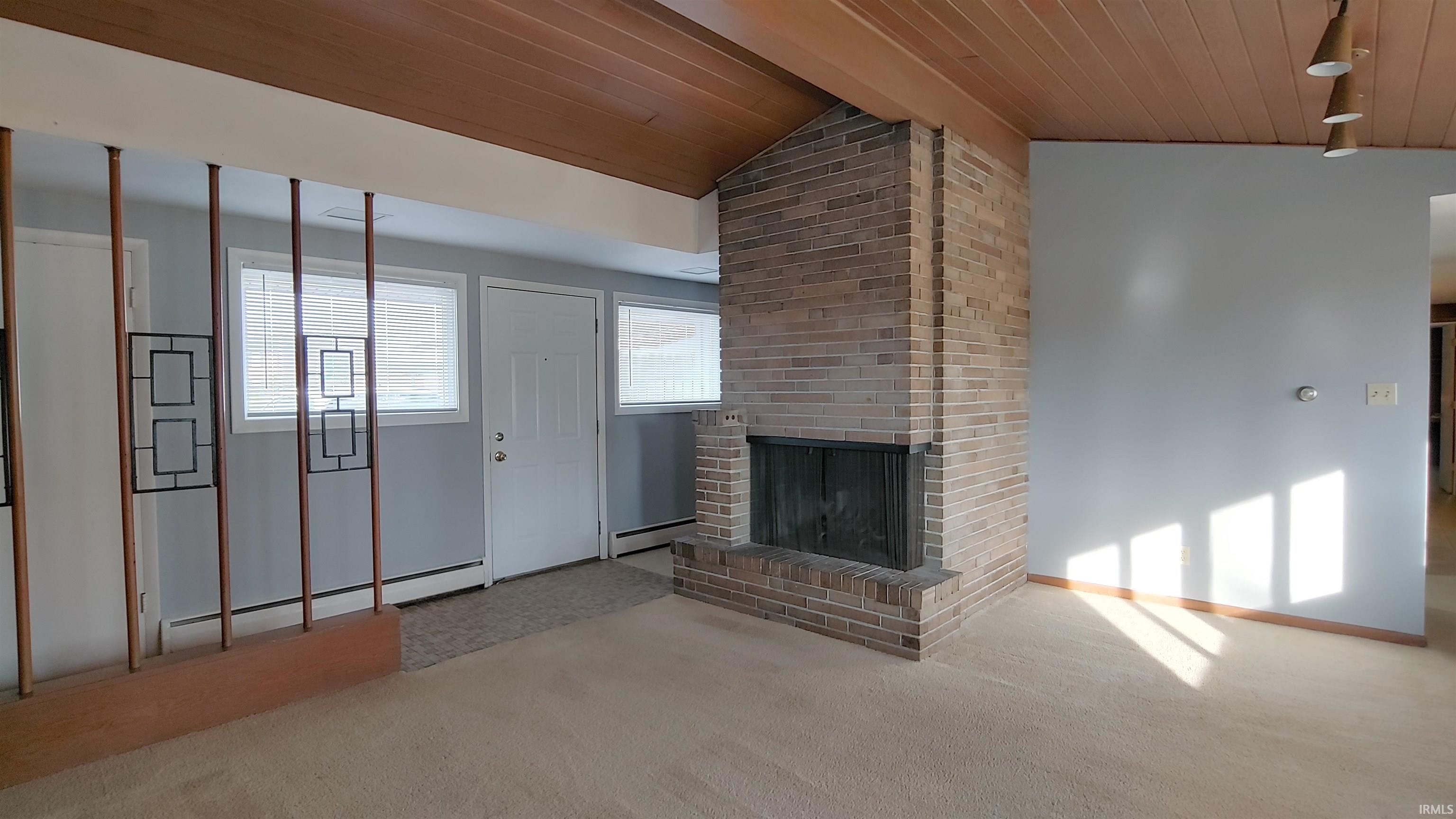 Living room featuring vaulted ceiling, fireplace, and MCM wood wall and ceiling