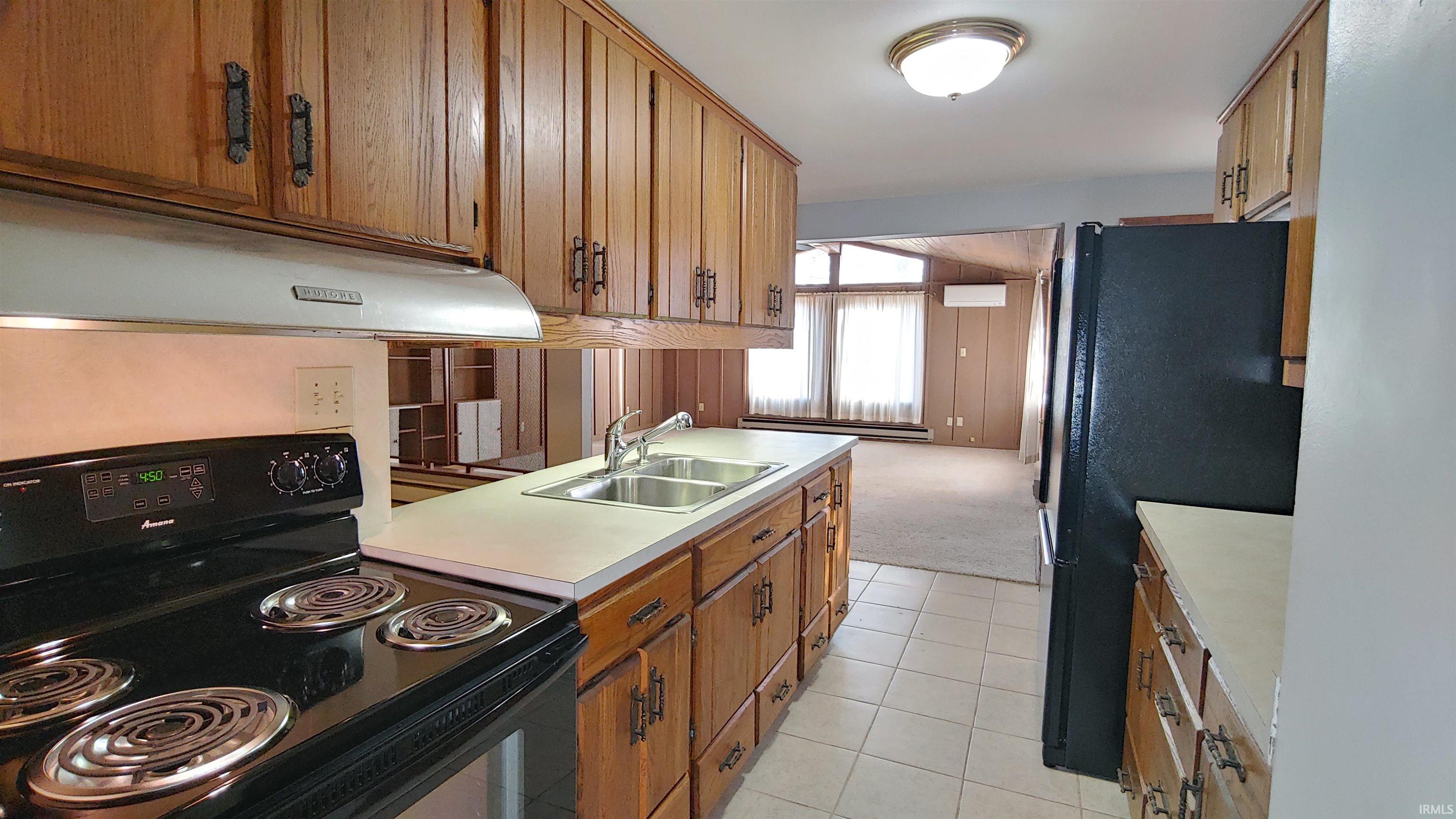 Kitchen with Electric range, range hood, Natural wood cabinets