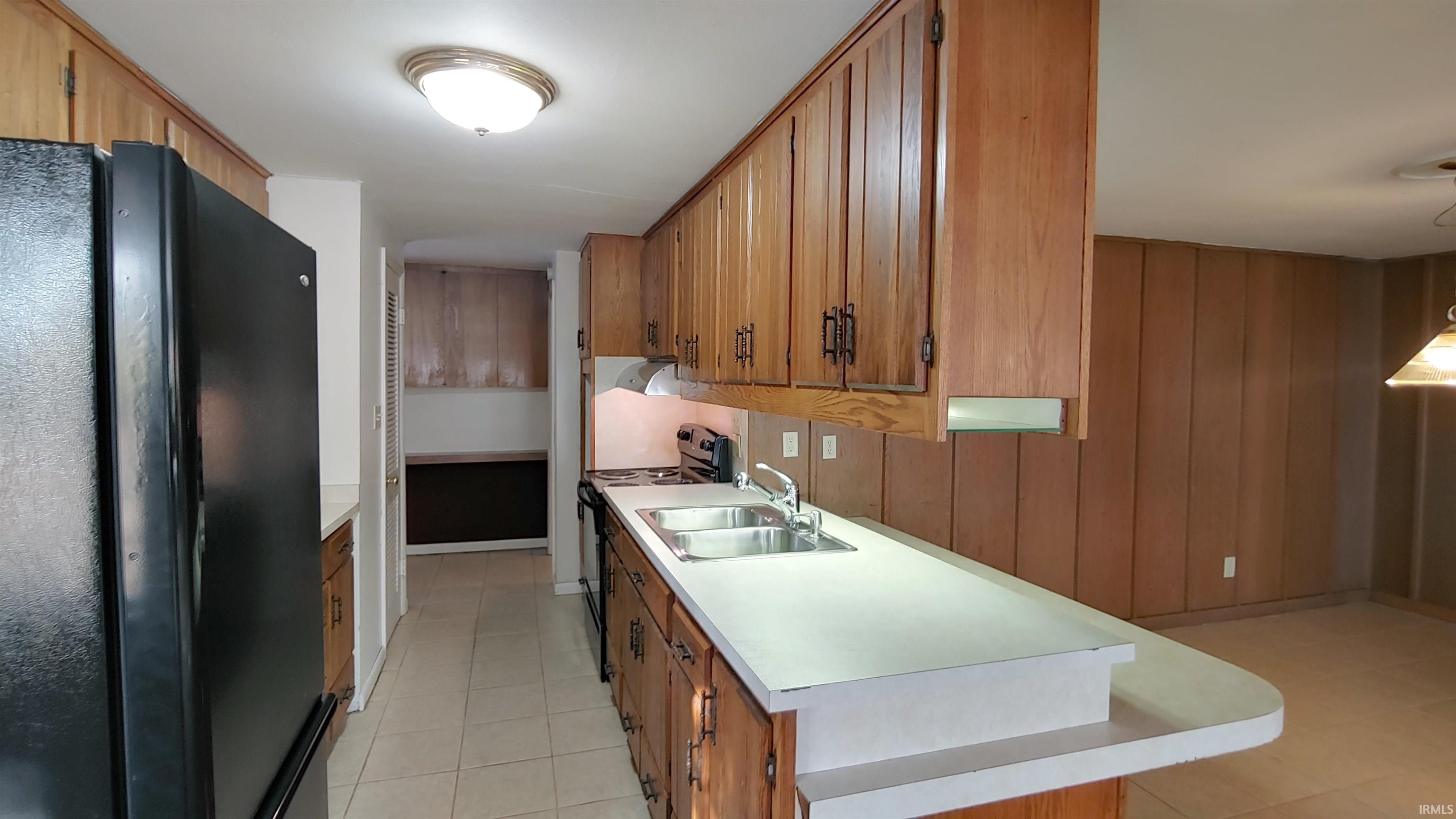 Kitchen featuring refrigerator and a peninsula counter