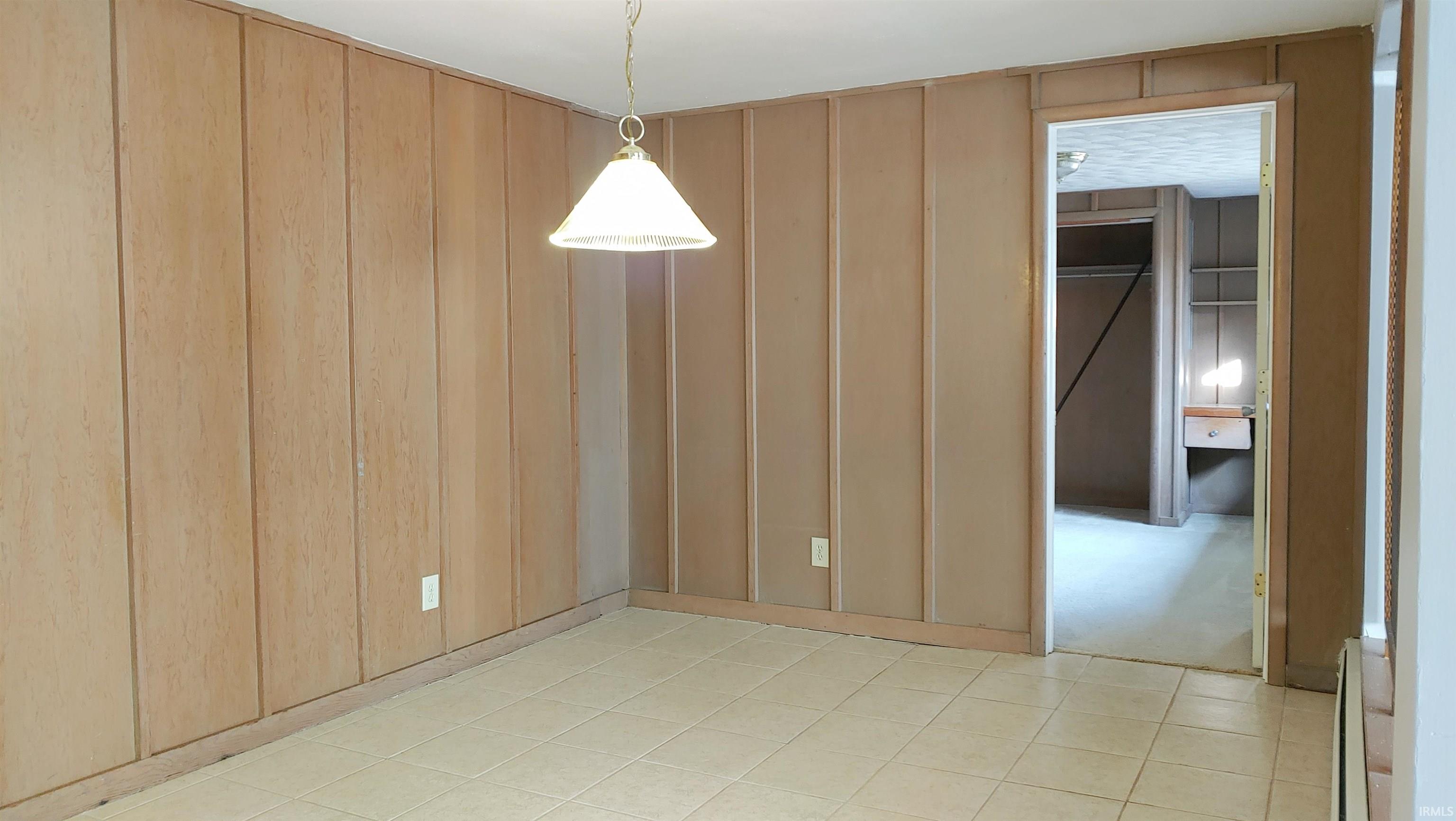 Dining room with ceramic flooring and MCM wood paneled walls