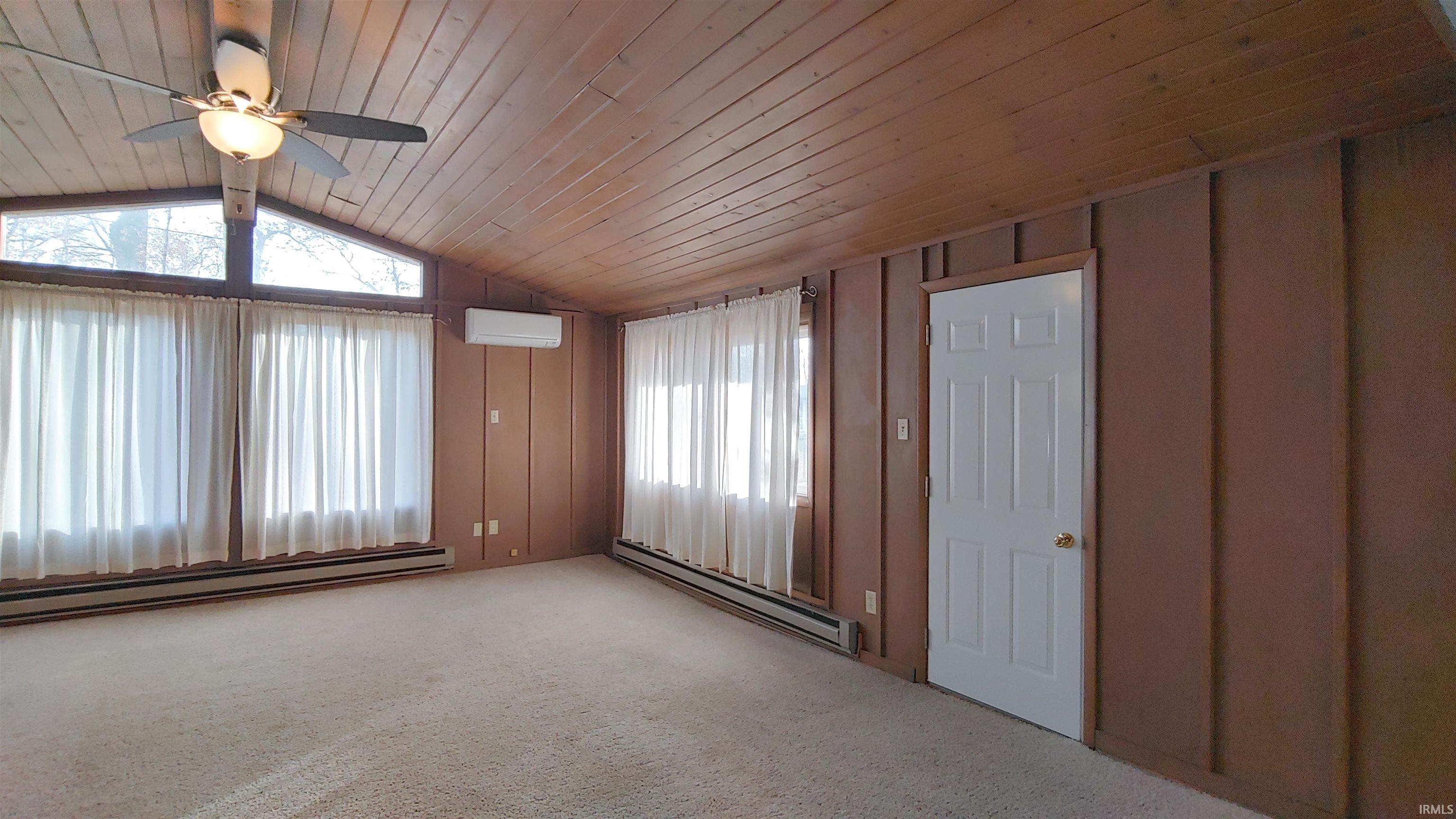 Family room with wood vaulted ceiling,ceiling fan and carpet