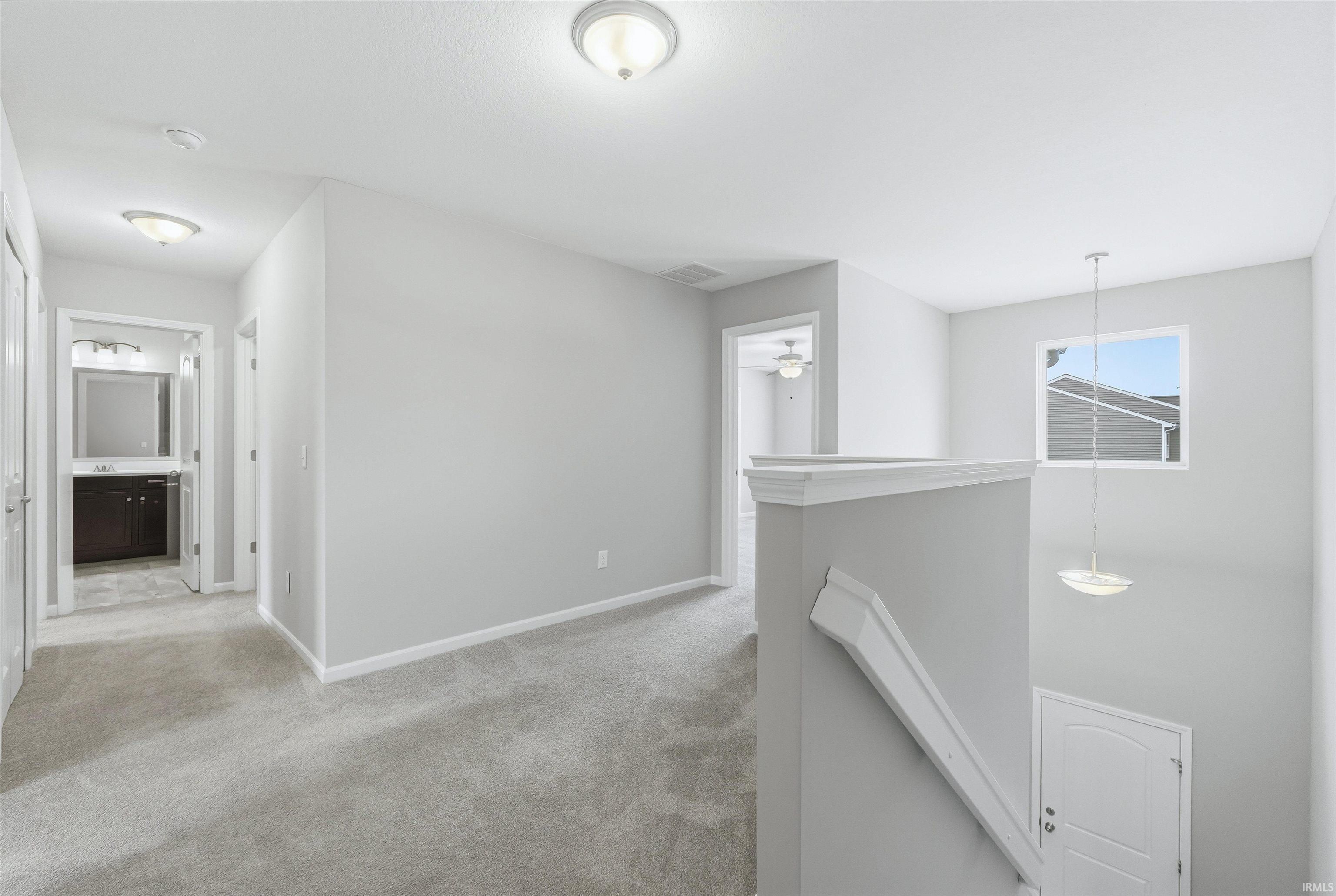 Corridor featuring an upstairs landing and light carpet