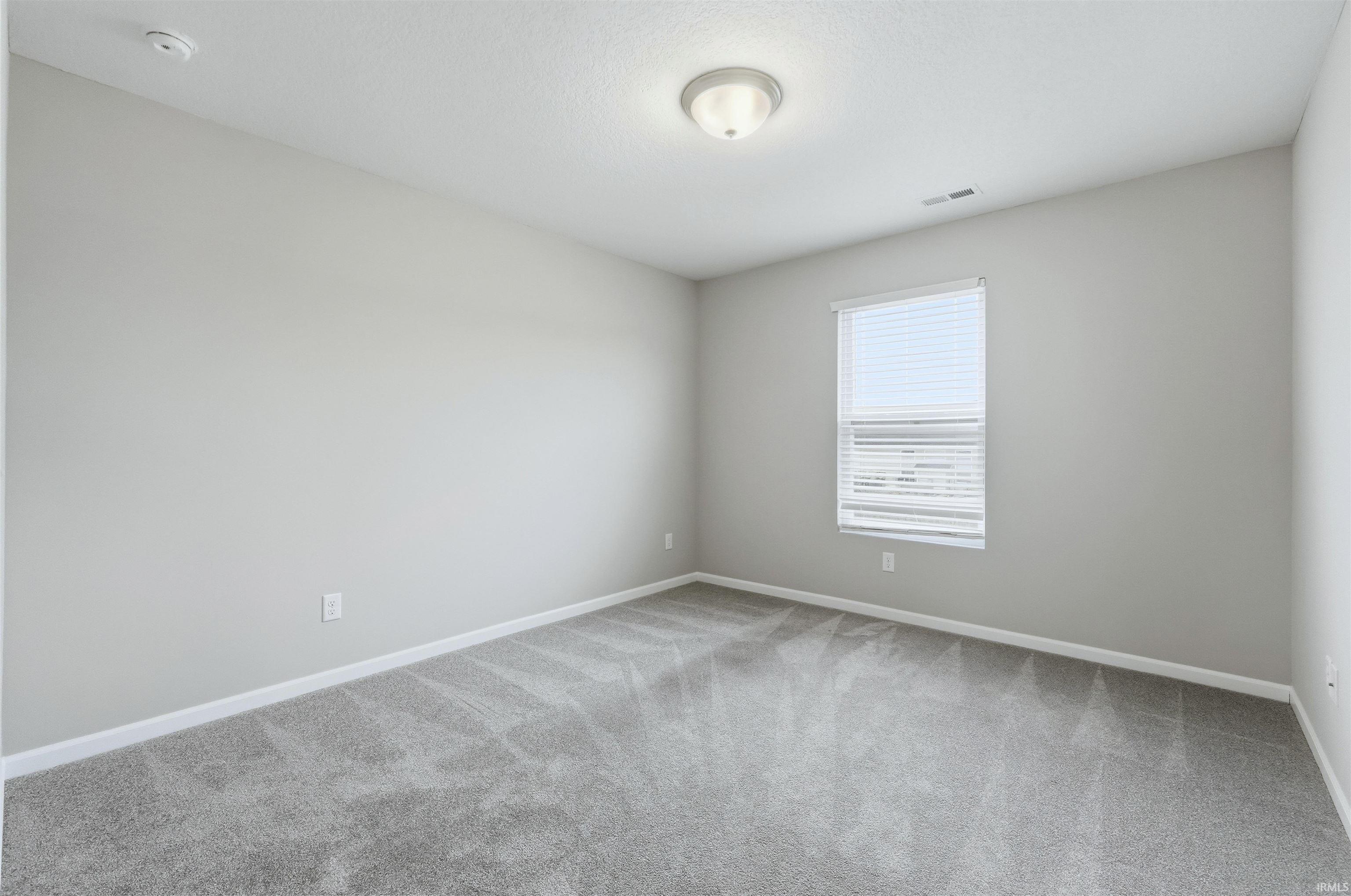 Bedroom featuring light carpet and walls