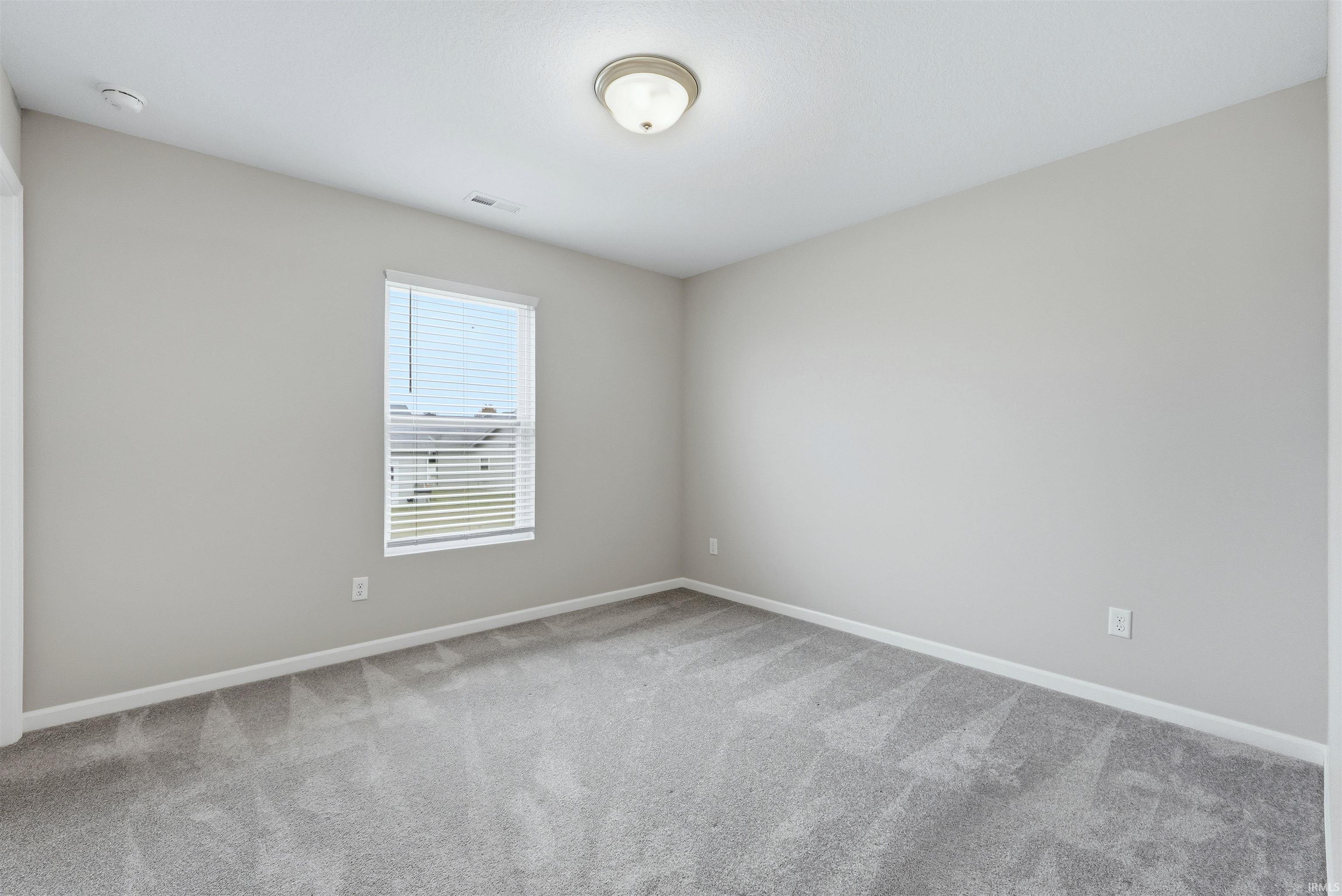 Bedroom featuring light carpet and walls