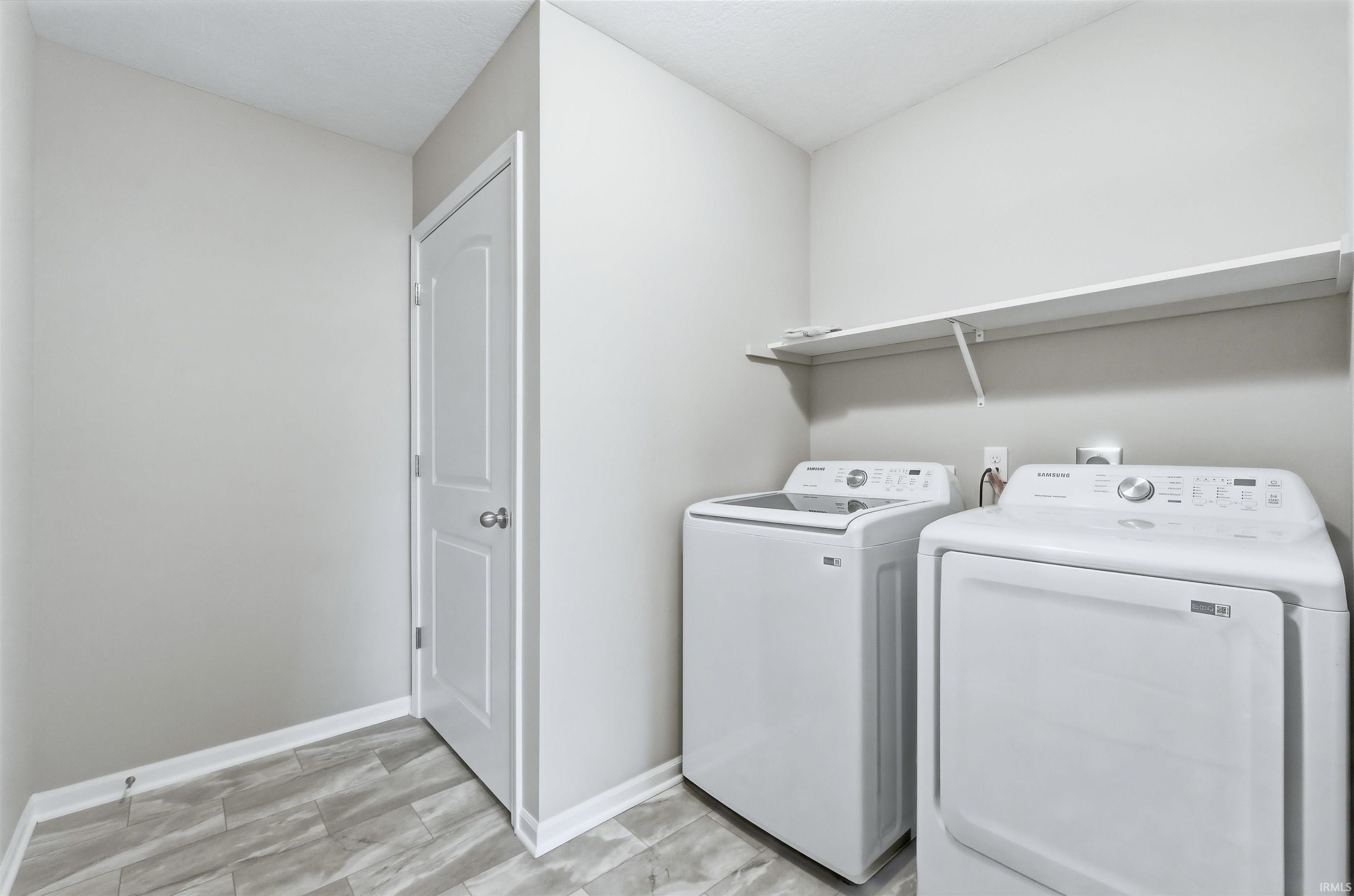 Laundry area featuring washer and dryer and vinyl plank flooring