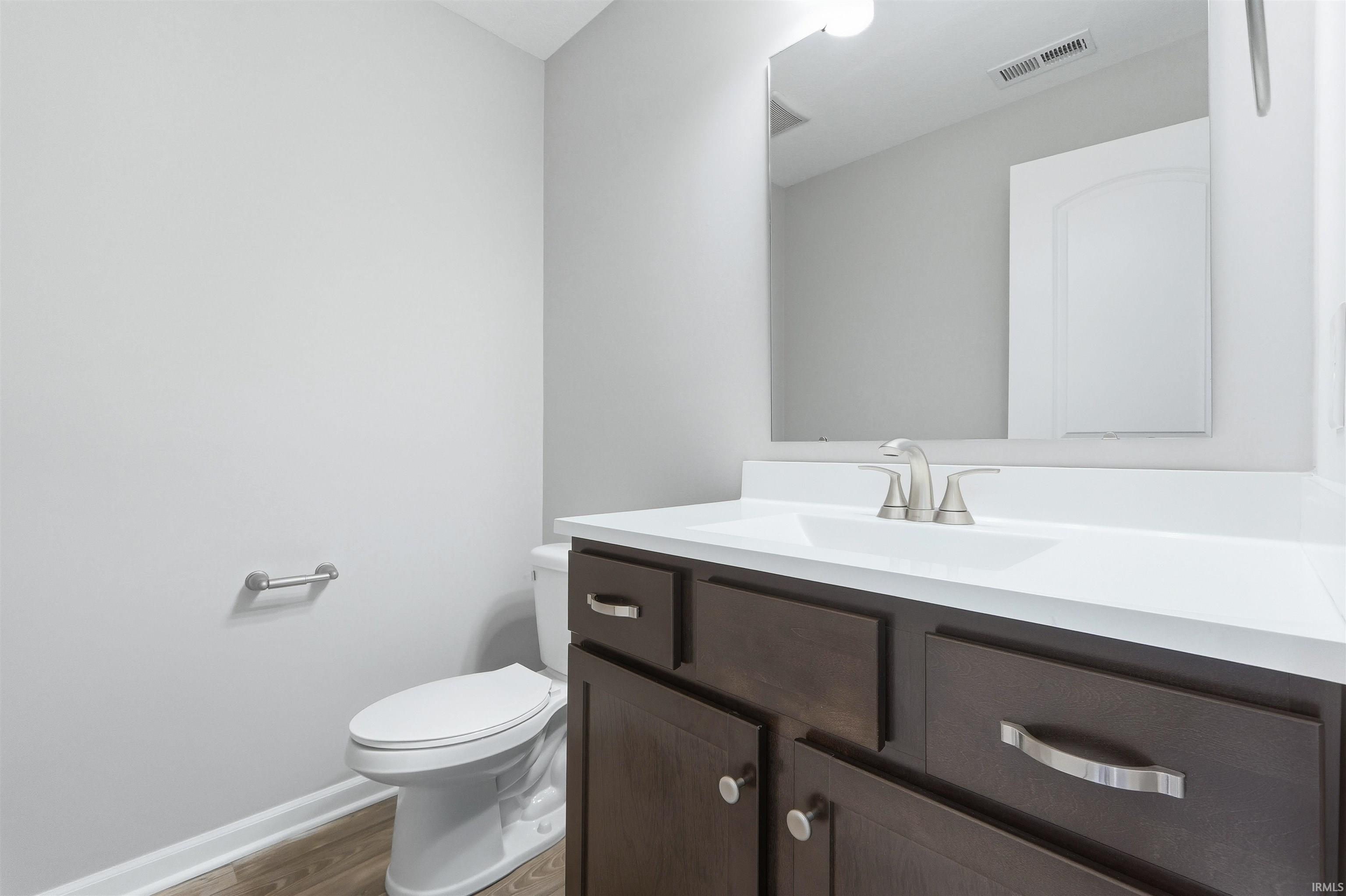 Half bath with vanity and light wood-style floors