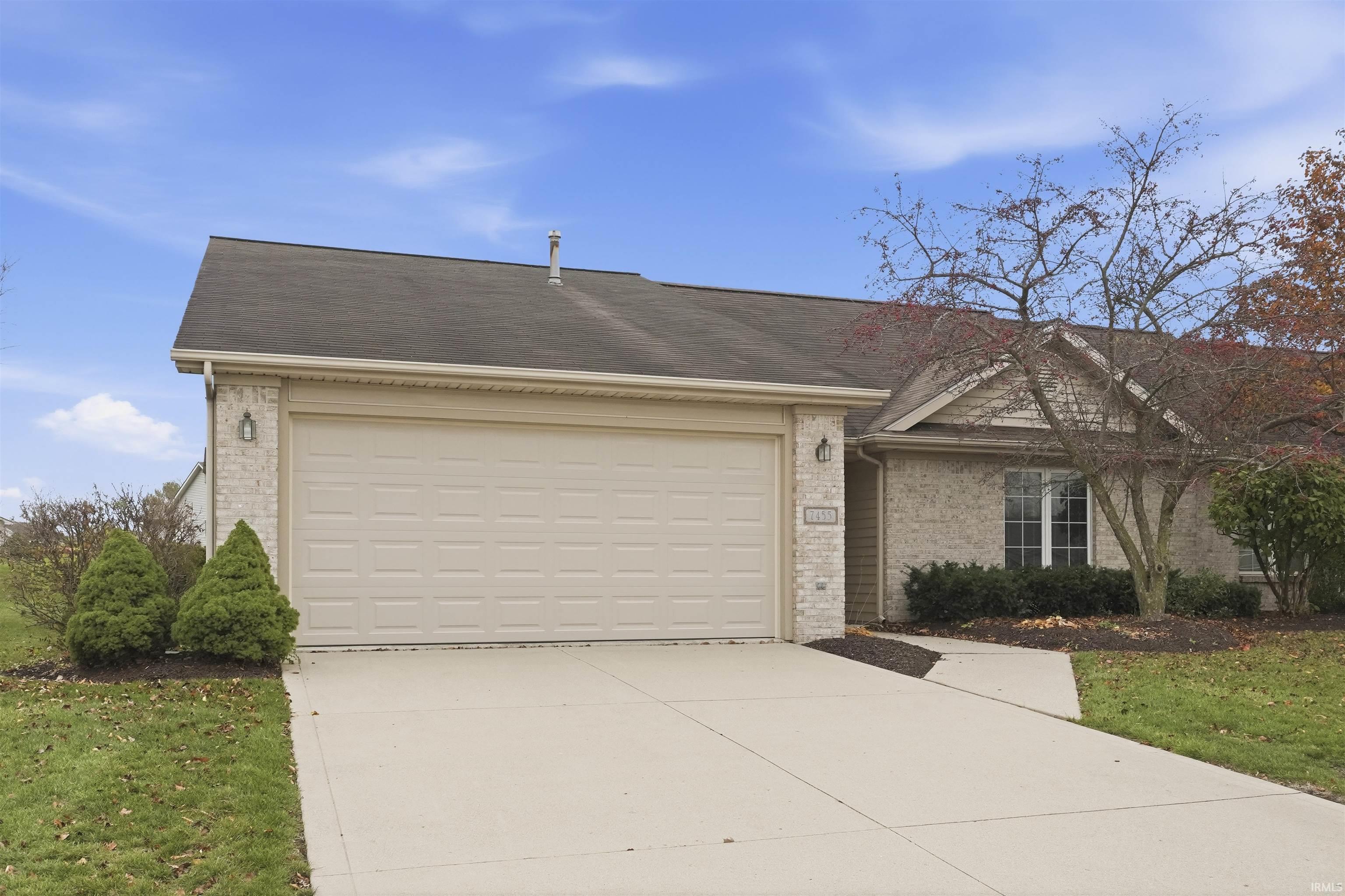View of front of property with driveway, brick siding, a garage, and a shingled roof