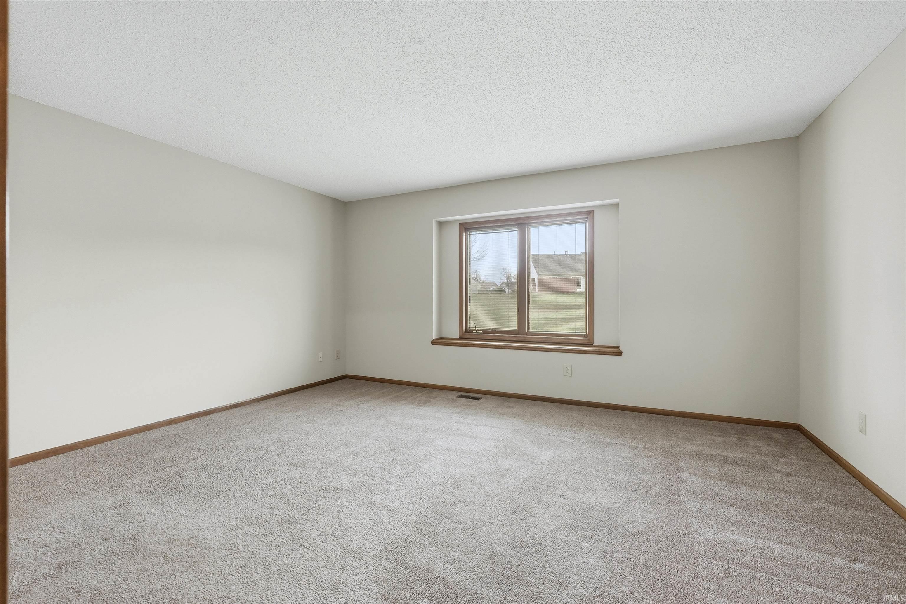 Bedroom featuring light walls and light colored carpet