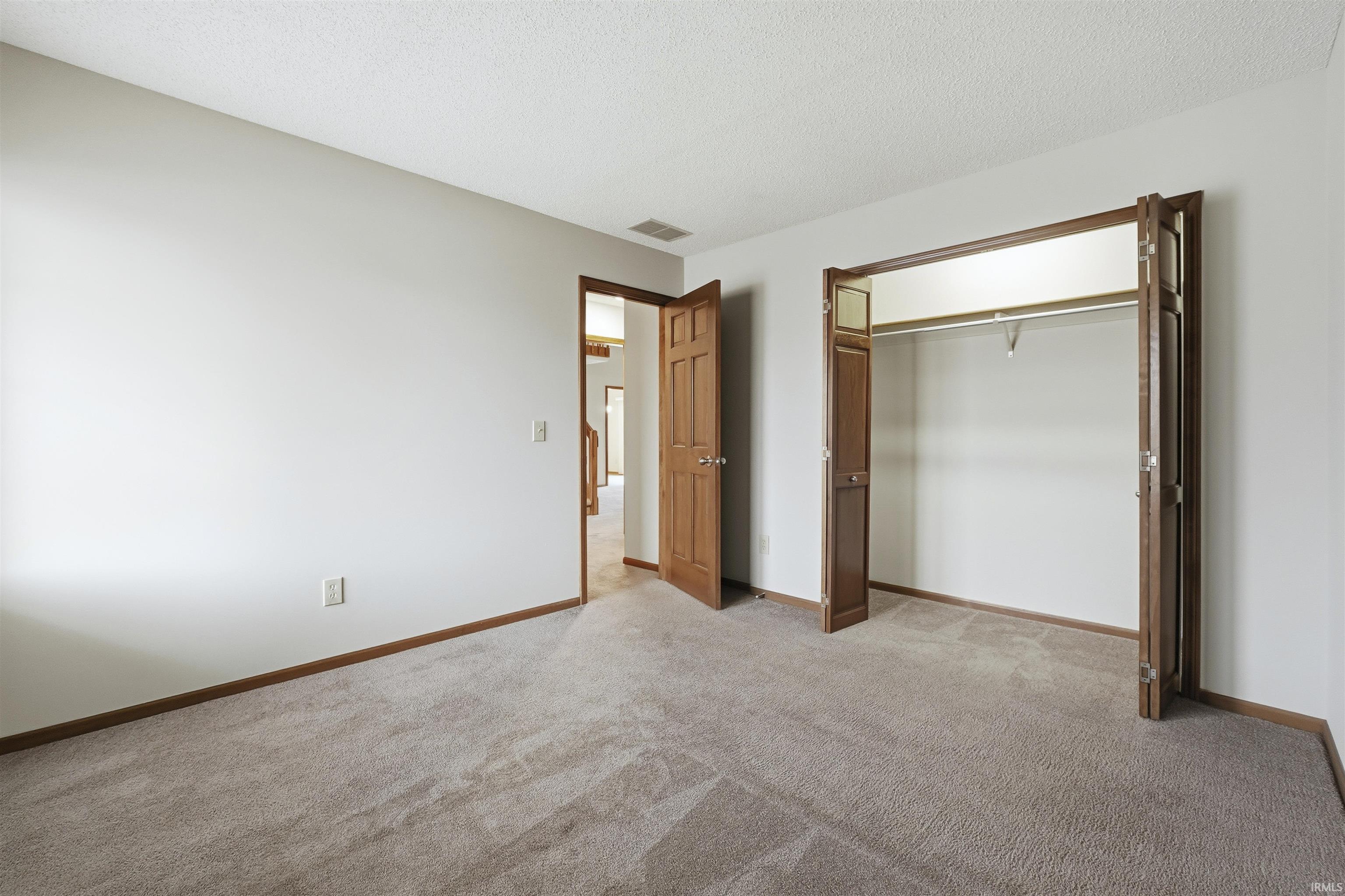 Bedroom featuring a closet, carpet flooring and light walls