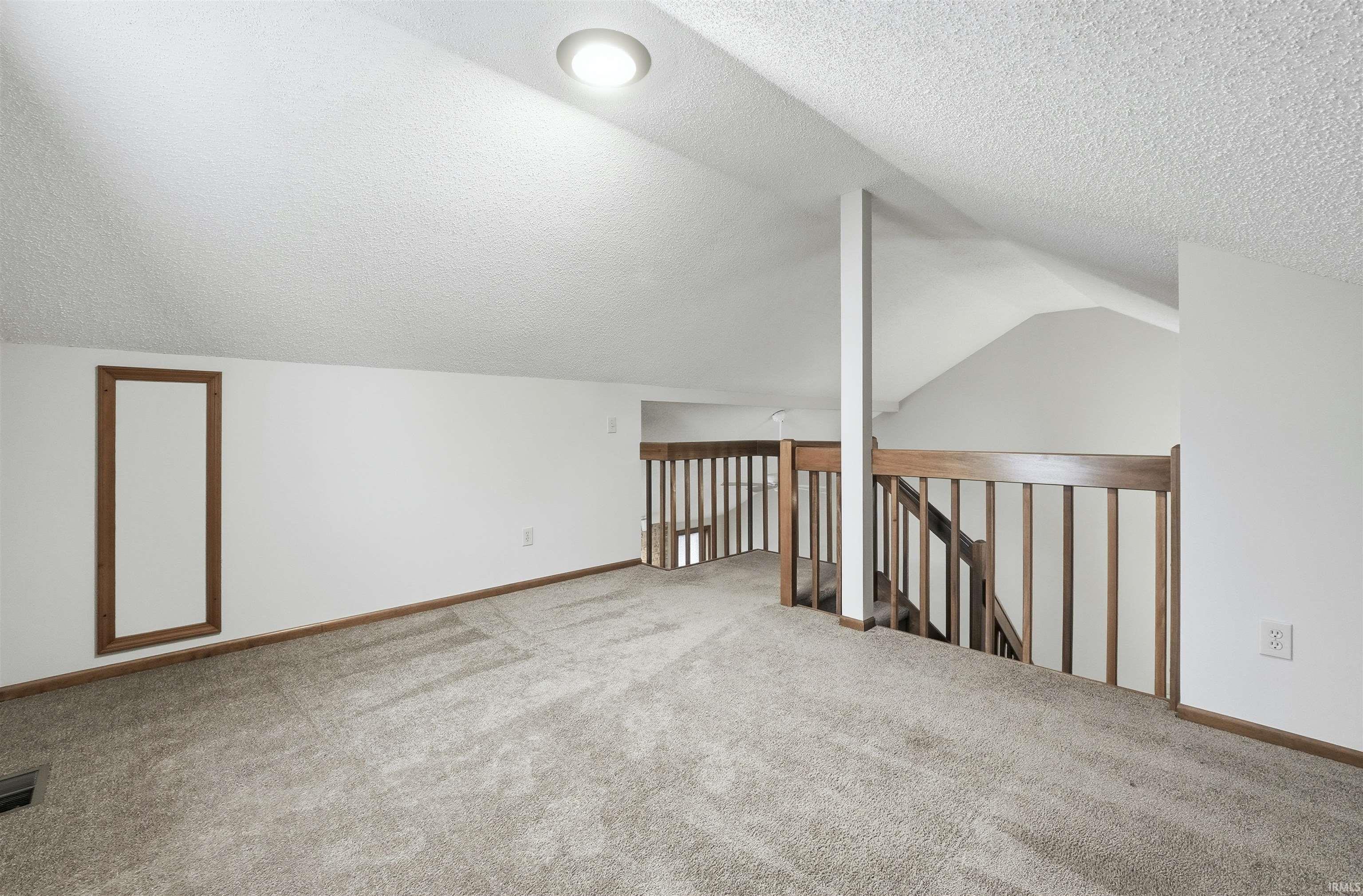 Bonus Loft with a textured ceiling, angled ceiling and carpet flooring
