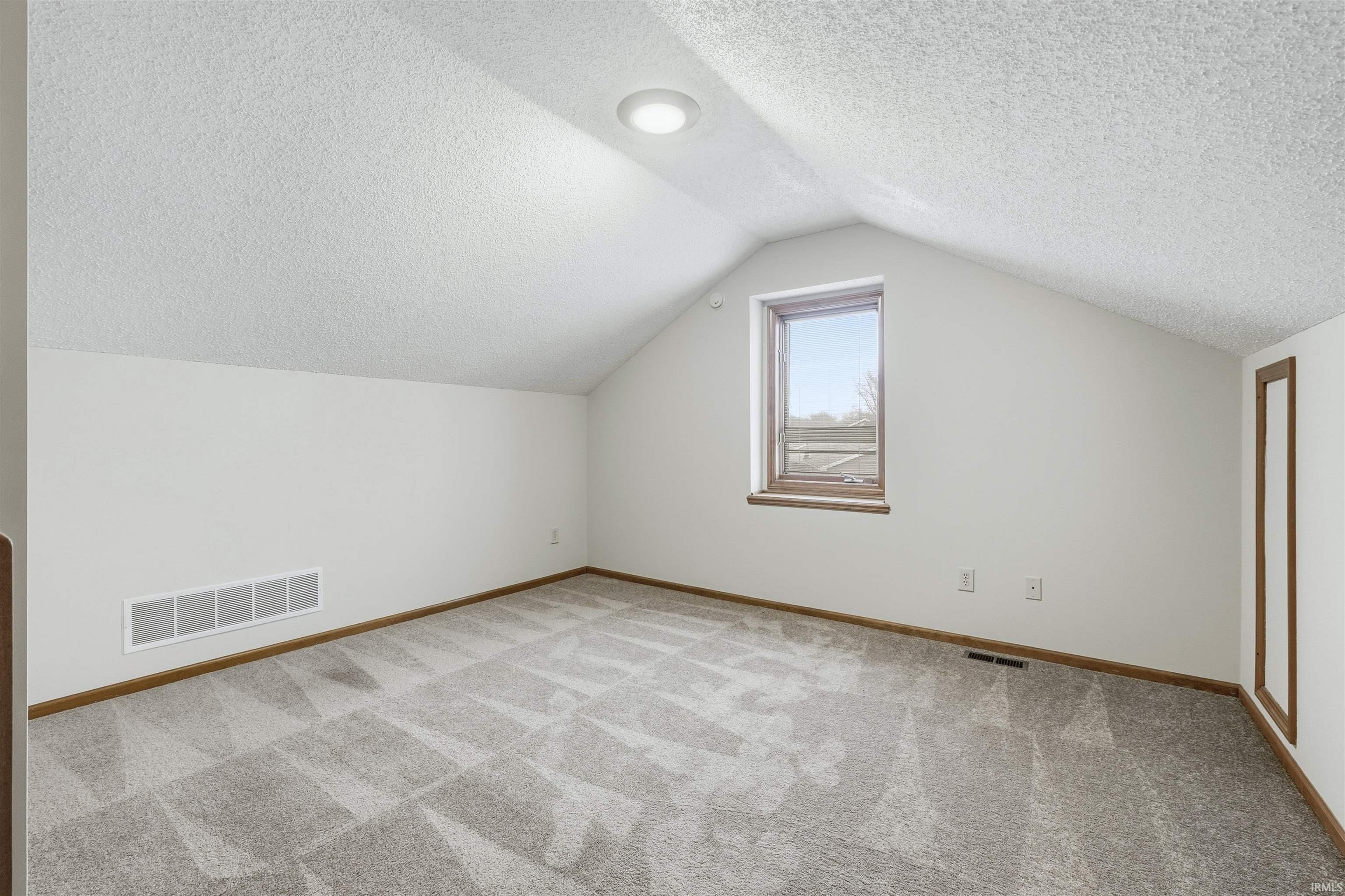 Bonus Loft with a textured ceiling, angled ceiling and carpet flooring