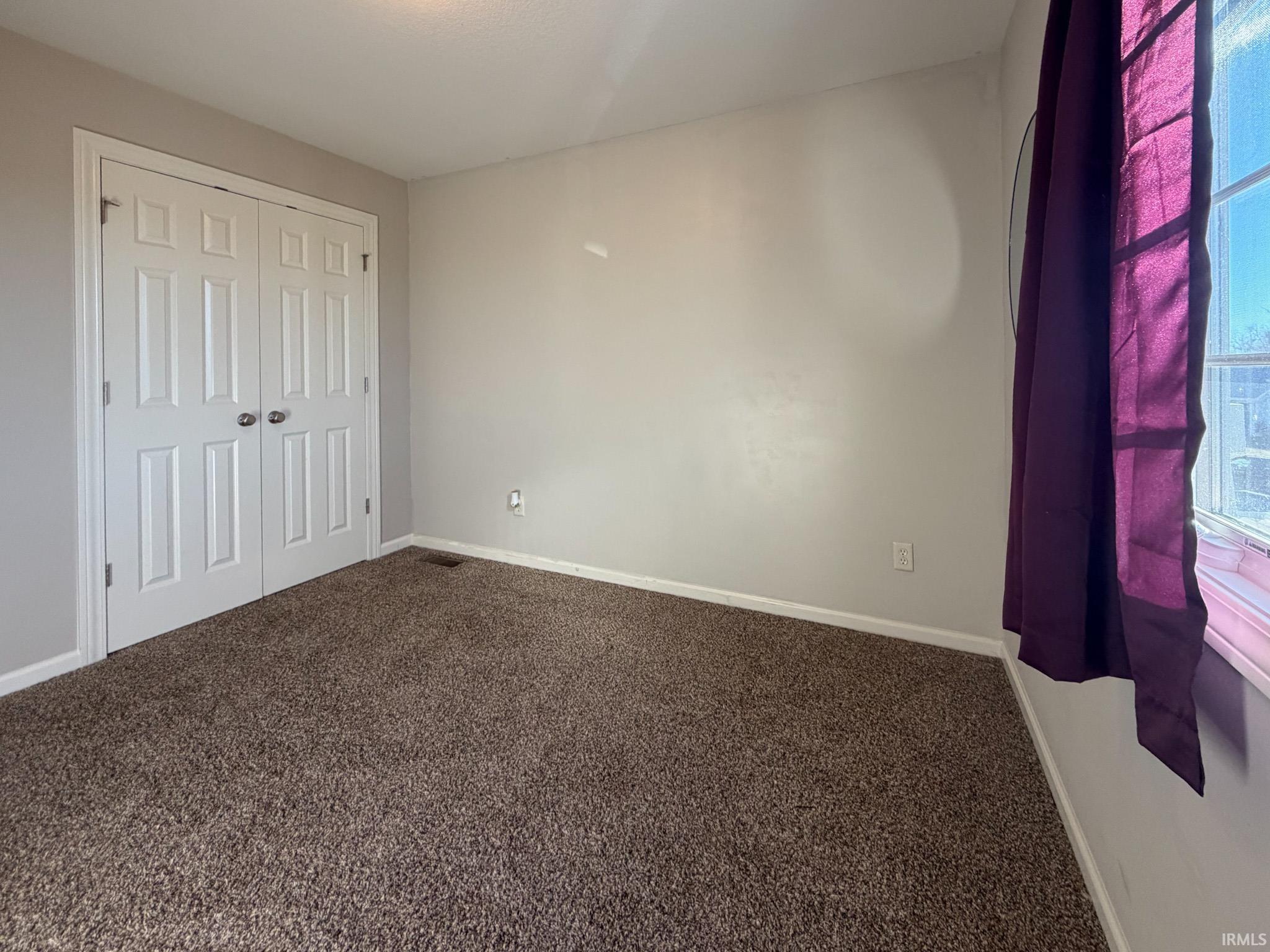 Unfurnished bedroom with carpet floors and a closet