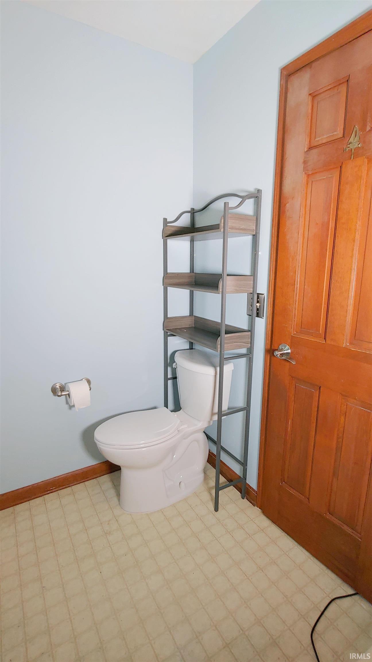 Bathroom featuring light flooring and toilet
