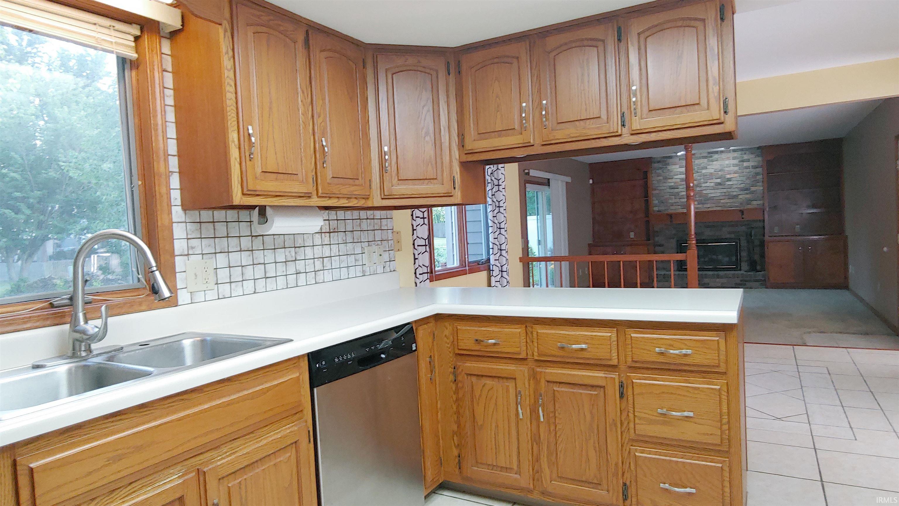 Kitchen with stainless sink, dishwasher and natural wood cabinets