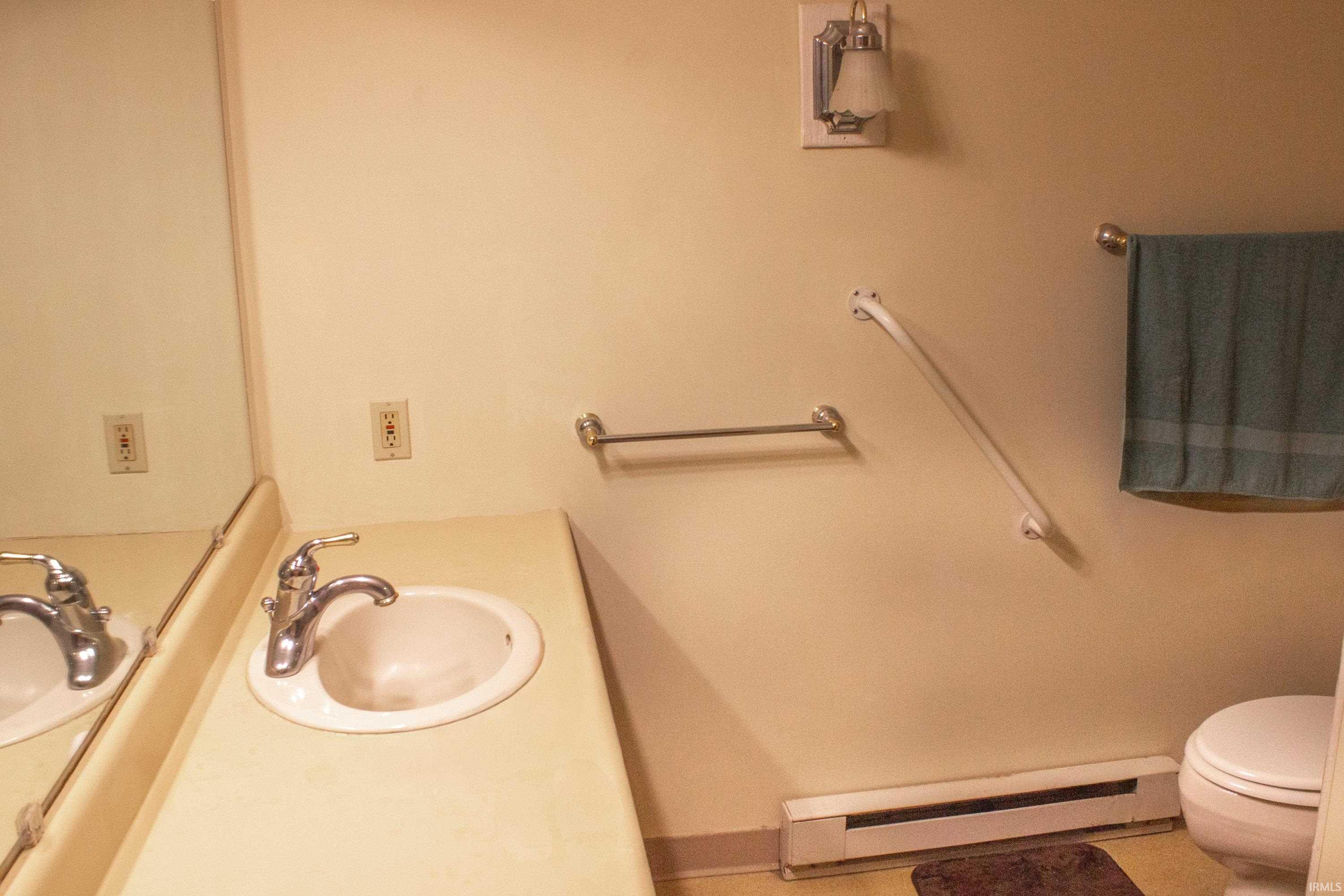 Bathroom featuring a baseboard heating unit and vanity