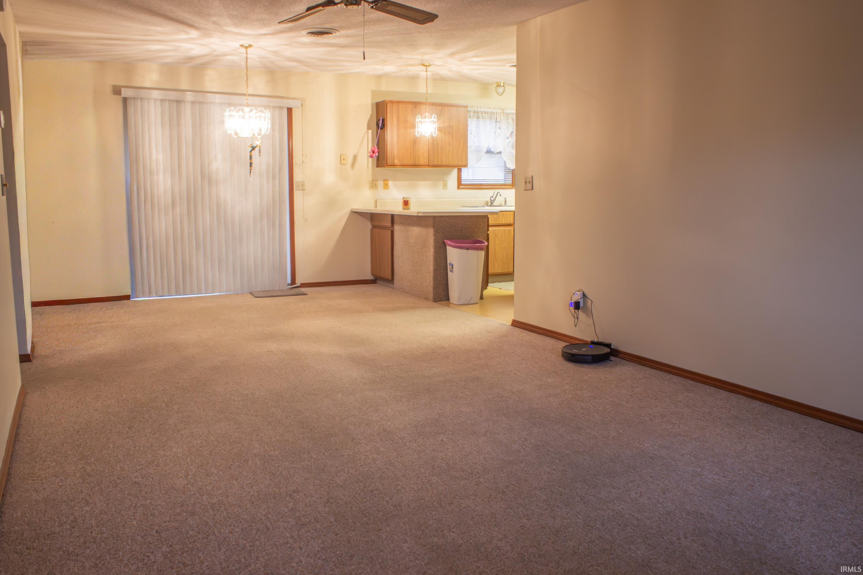 Spare room featuring light colored carpet and a ceiling fan