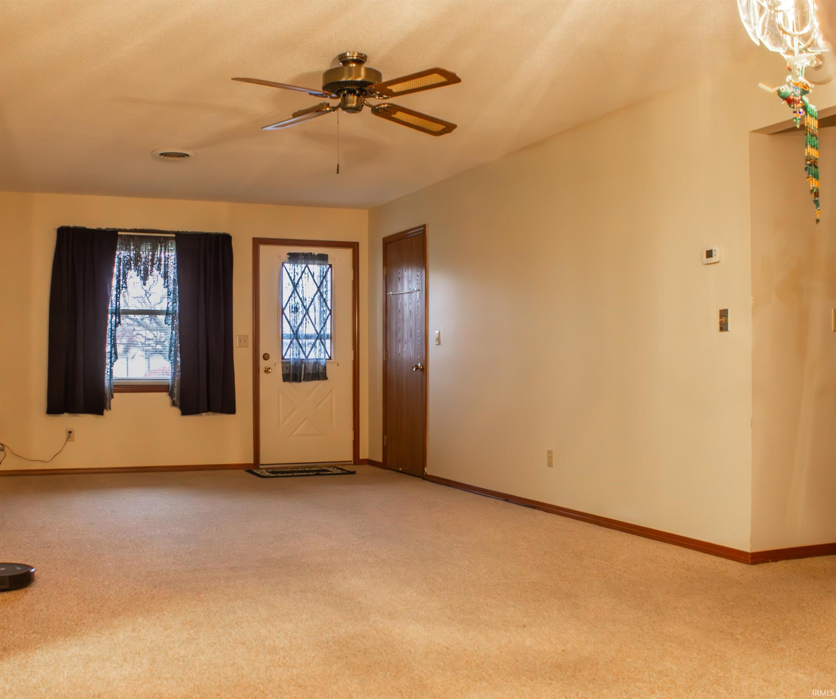 Foyer with carpet flooring and a ceiling fan