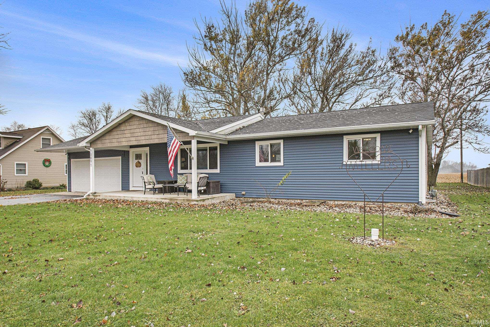 Single story home with concrete driveway, a front yard, an attached garage, and roof with shingles