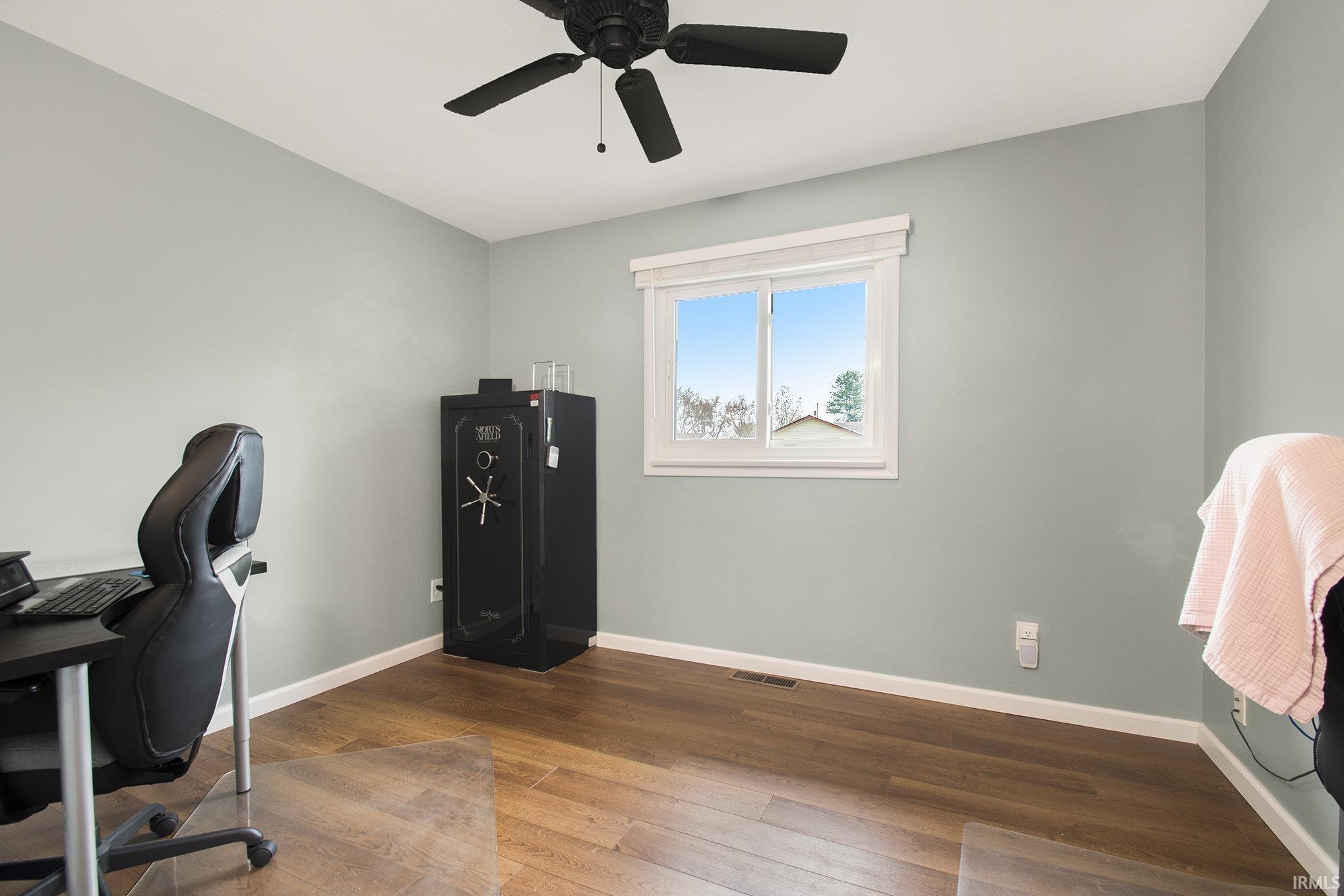 Office space with dark wood-style flooring and a ceiling fan on the main level