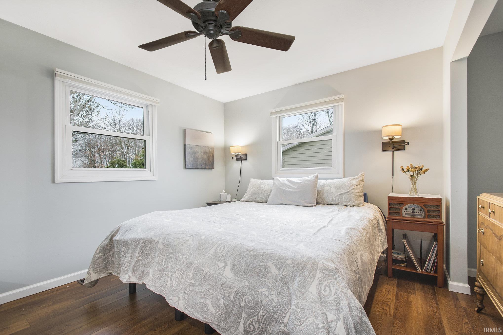 Bedroom with a ceiling fan and dark wood finished floors