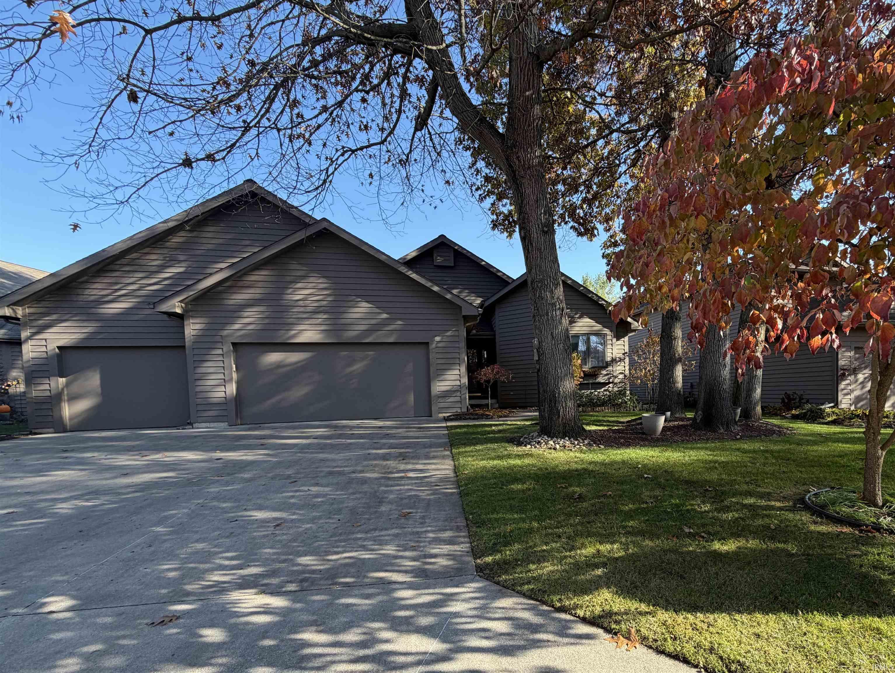 View of front of house featuring a garage, driveway, and a front lawn