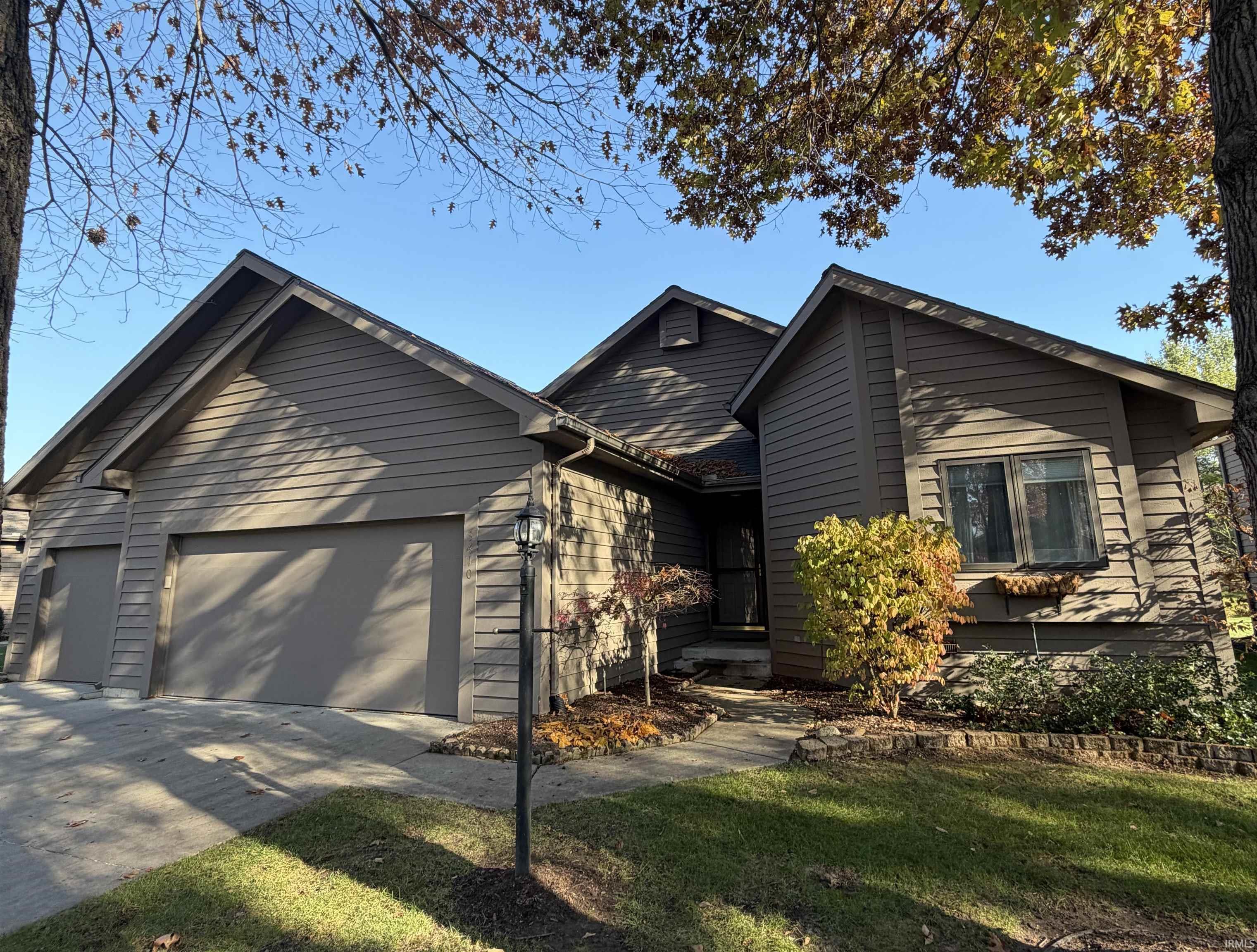 View of front of home with an attached garage, driveway, and a front yard