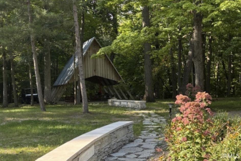 View of home's community with a forest view and a yard