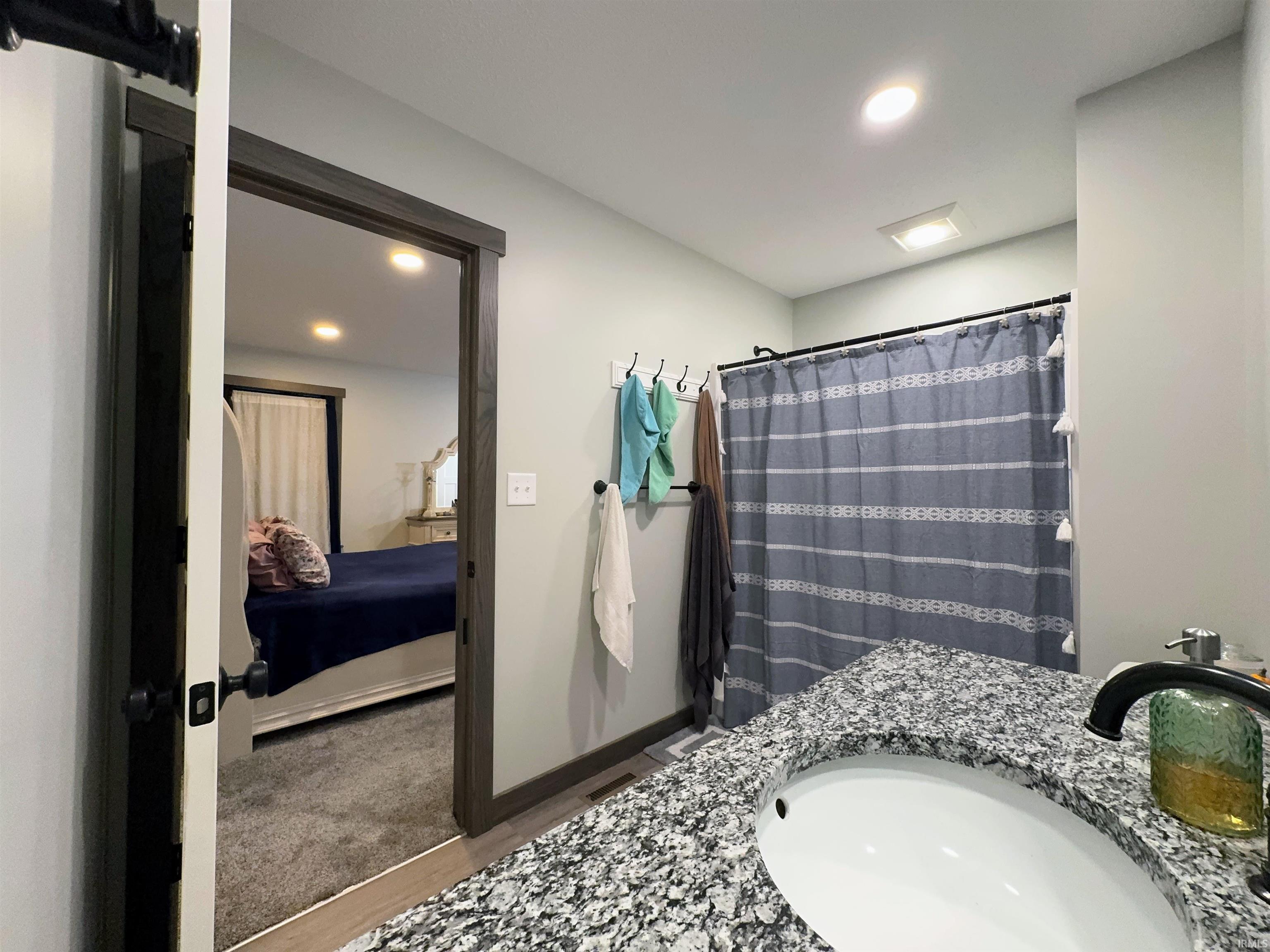 Bathroom featuring vanity, curtained shower, recessed lighting, and connected bathroom