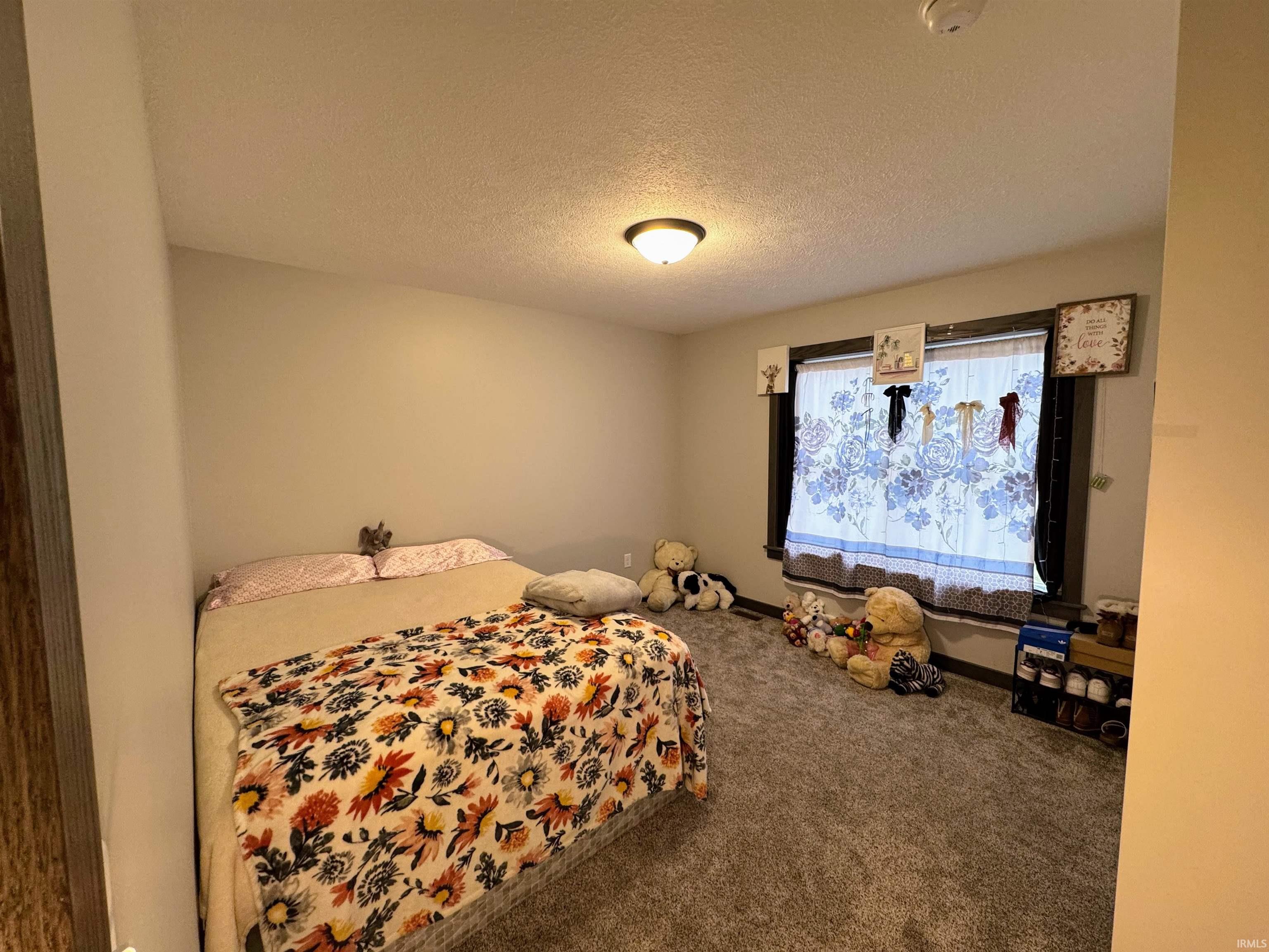 Bedroom featuring a textured ceiling and carpet