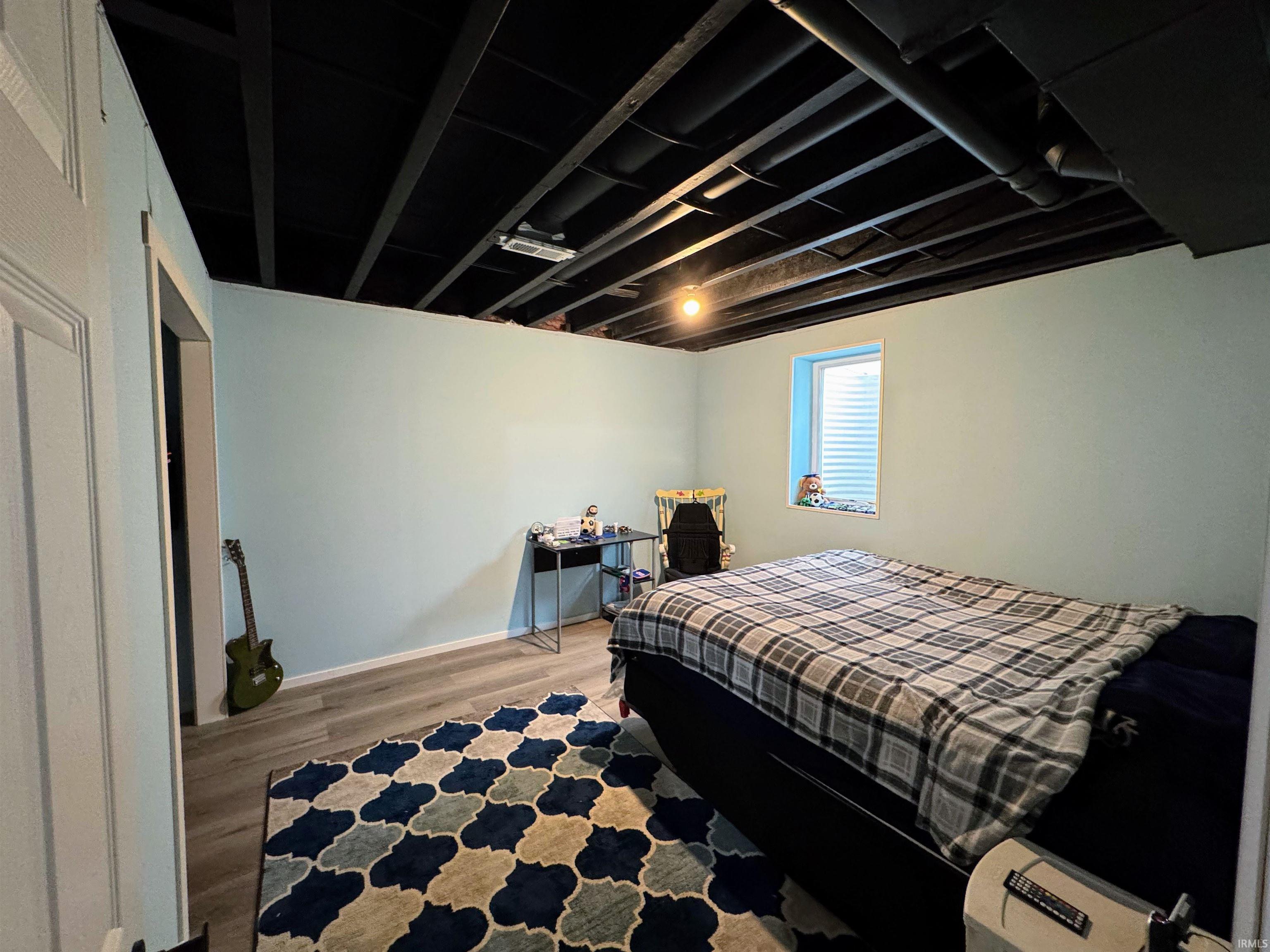 Bedroom featuring wood finished floors and baseboards