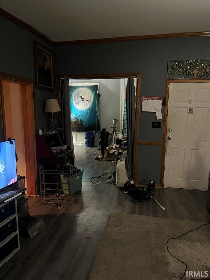 Foyer with ornamental molding and dark wood-style flooring