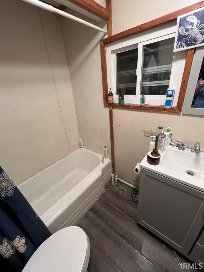 Bathroom featuring vanity, dark wood-style flooring, and bathing tub / shower combination