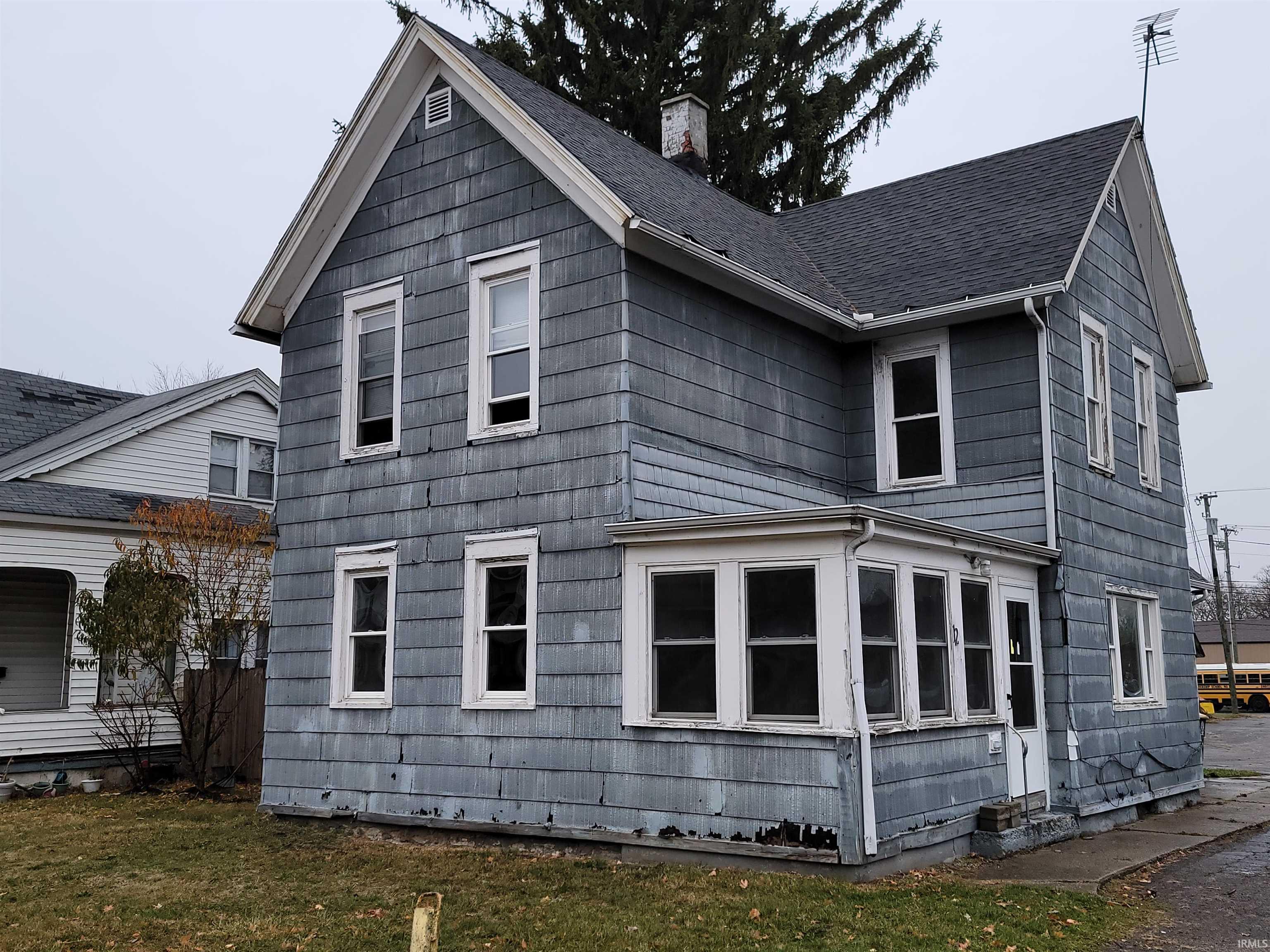 View of home's exterior featuring a chimney and a yard