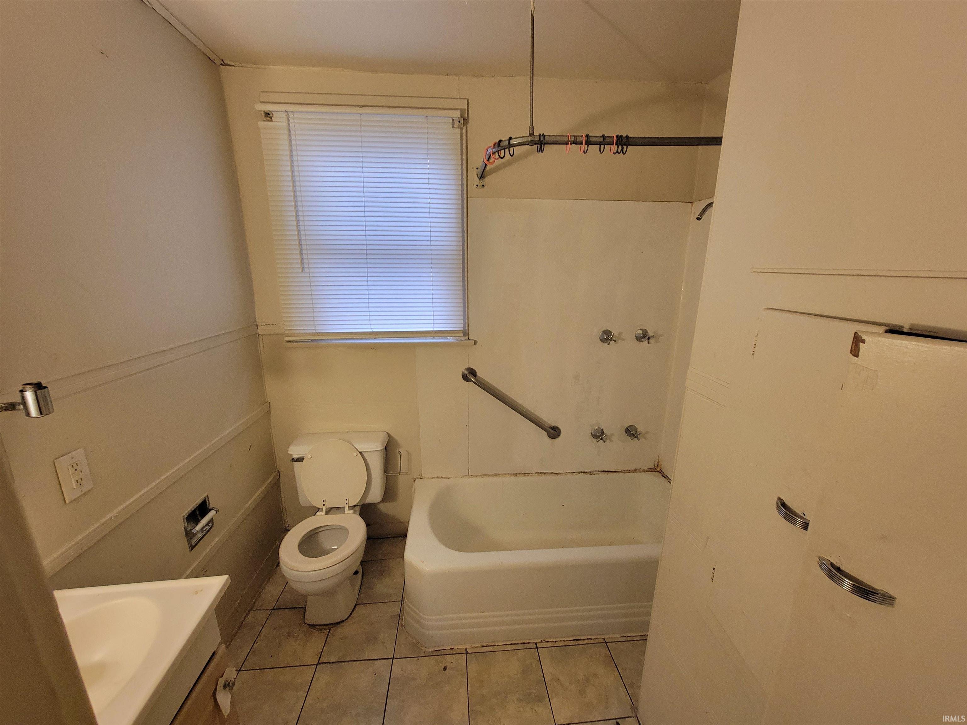 Bathroom with light tile patterned floors, vanity, and shower / bathtub combination