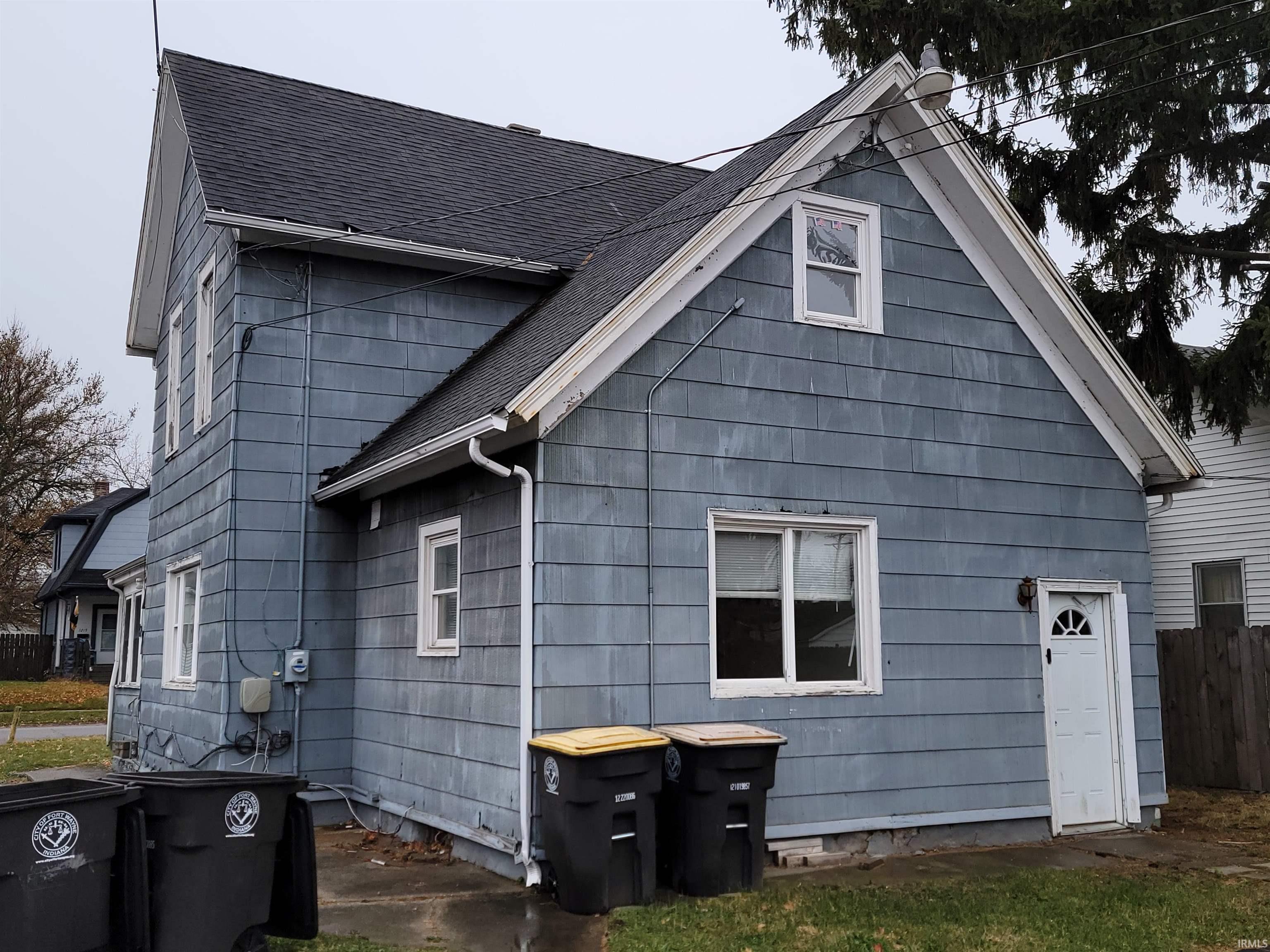 View of side of home with a shingled roof