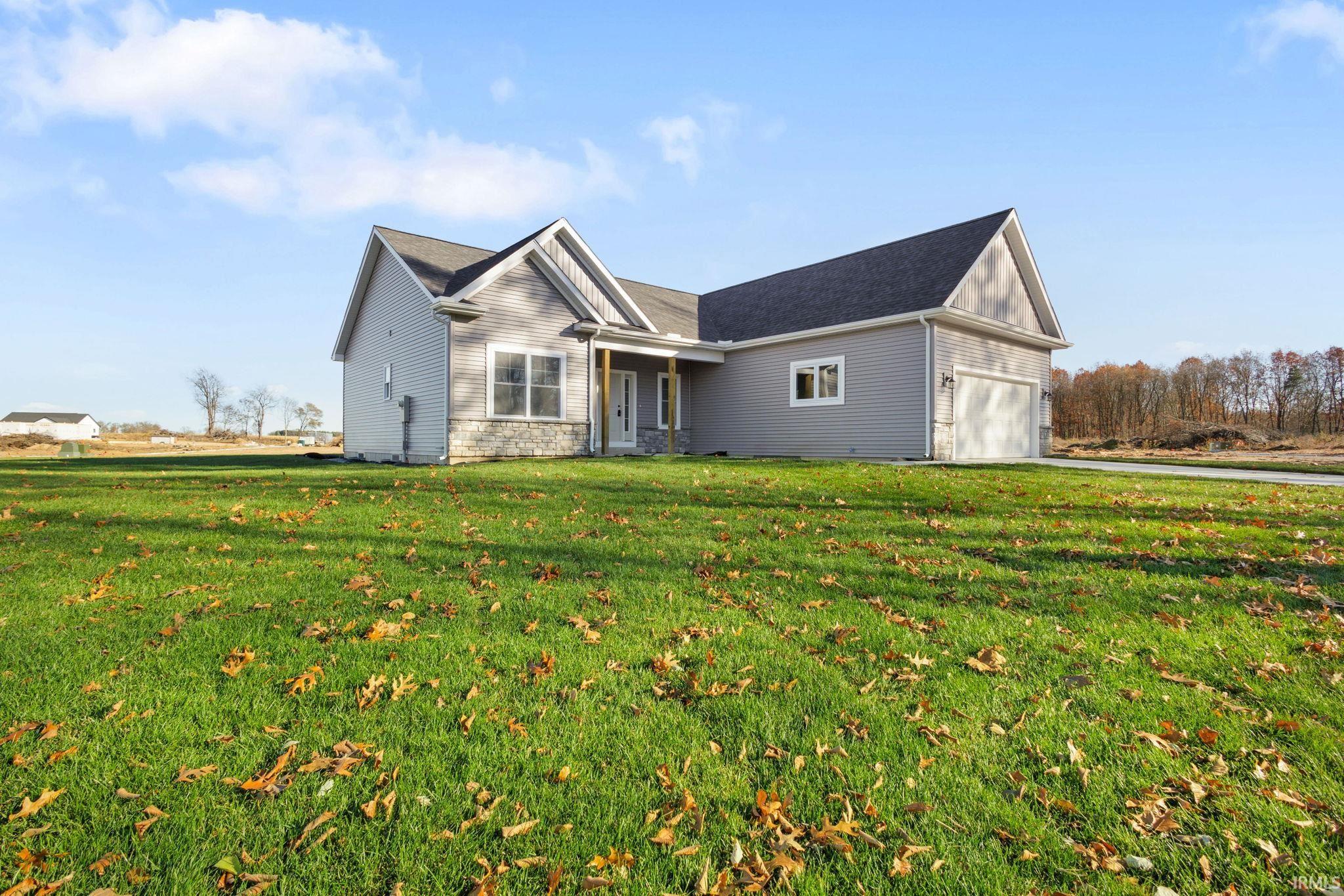 View of front facade with a front lawn, an attached garage, and stone siding