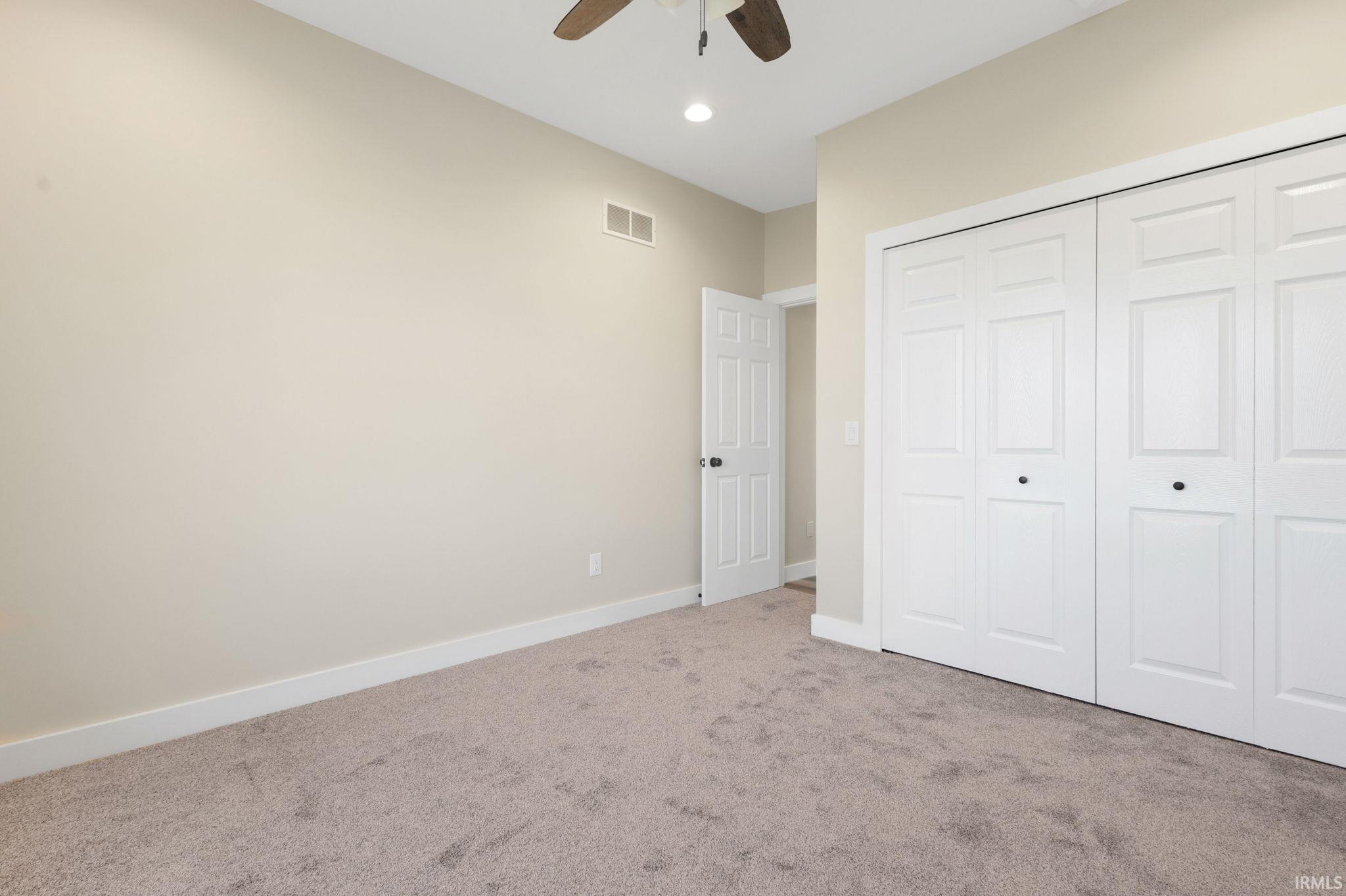 Unfurnished bedroom featuring carpet flooring, a closet, recessed lighting, and a ceiling fan