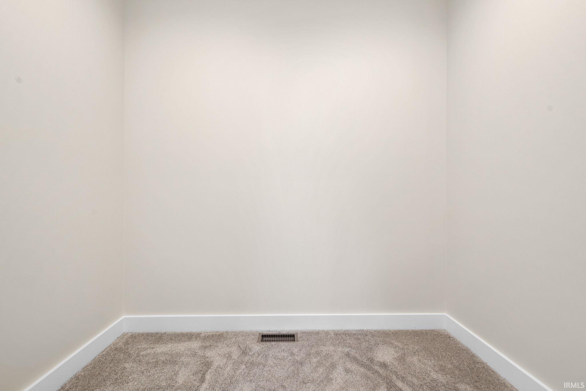 Carpeted empty room featuring baseboards