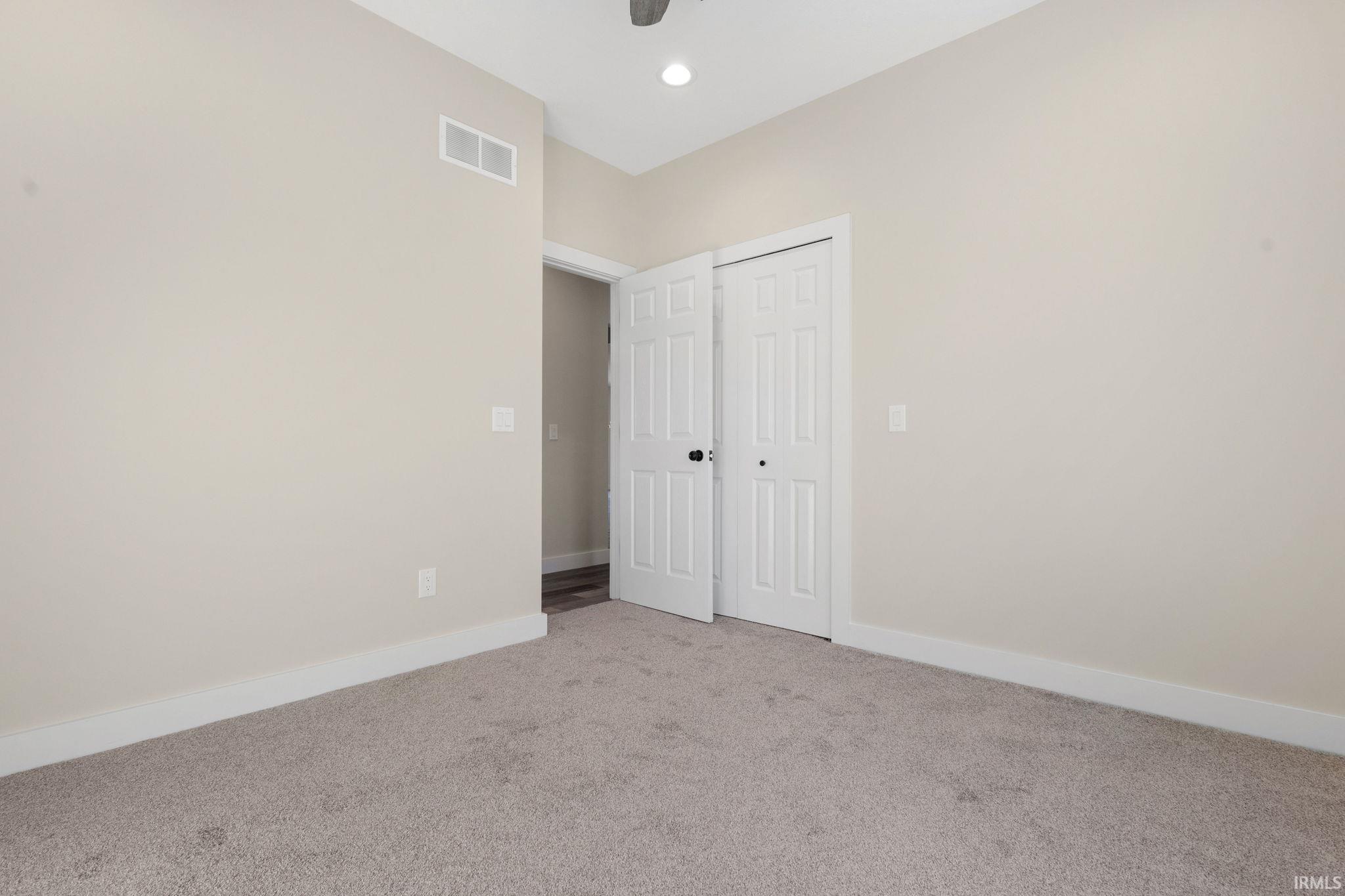 Unfurnished bedroom featuring light carpet, a closet, recessed lighting, and a ceiling fan